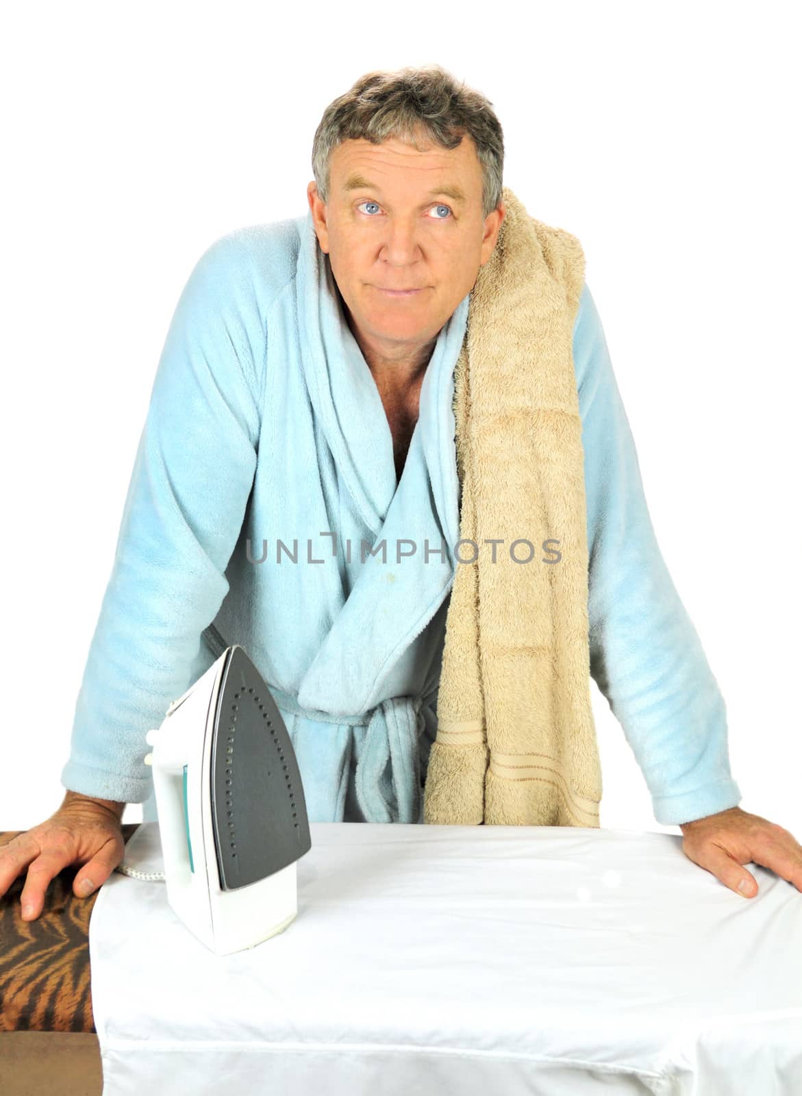Middle aged man in bath robe contempating having to iron.