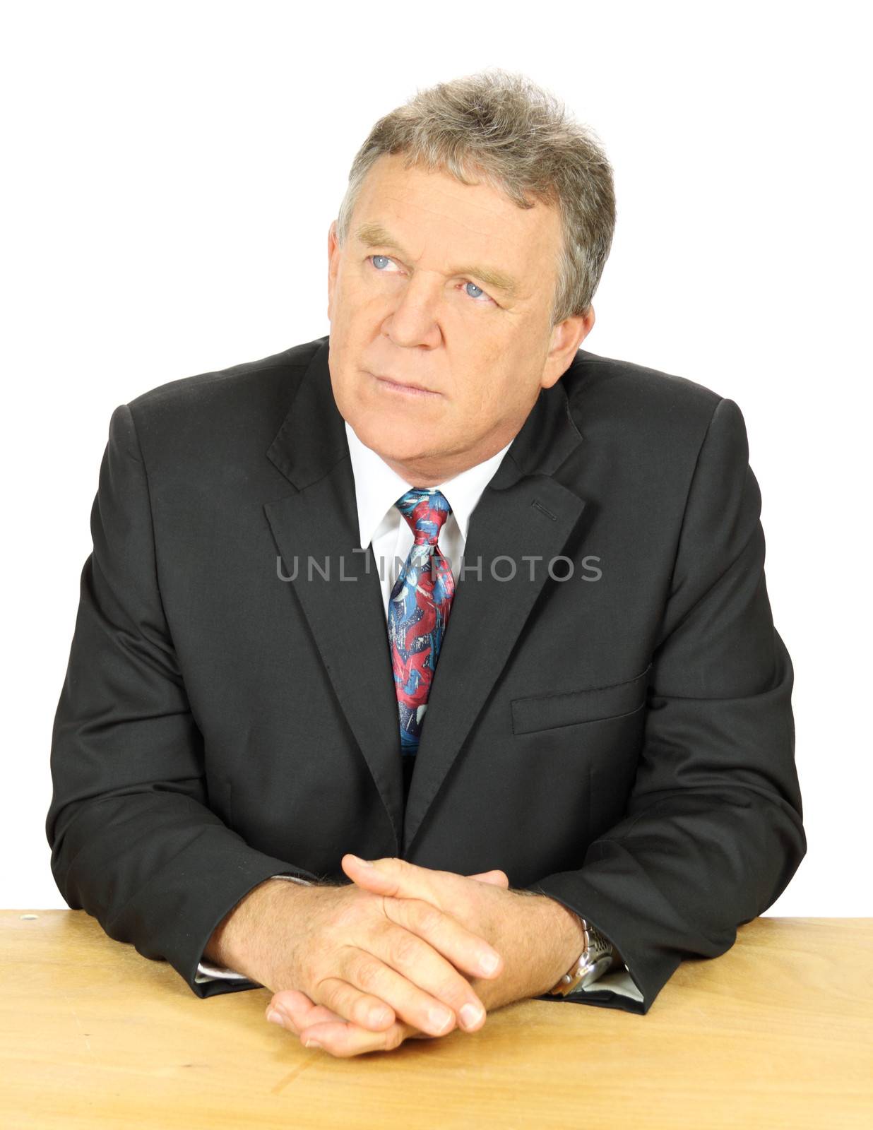 Seated middle aged businessman listens with interest.