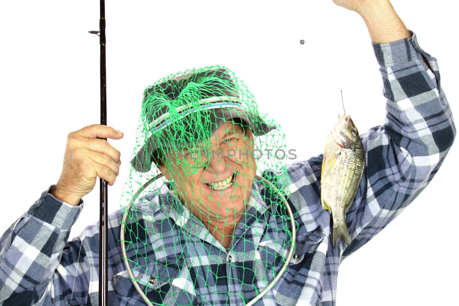 Middle aged fisherman ends up with fishing net over his head trying to catch a fish.