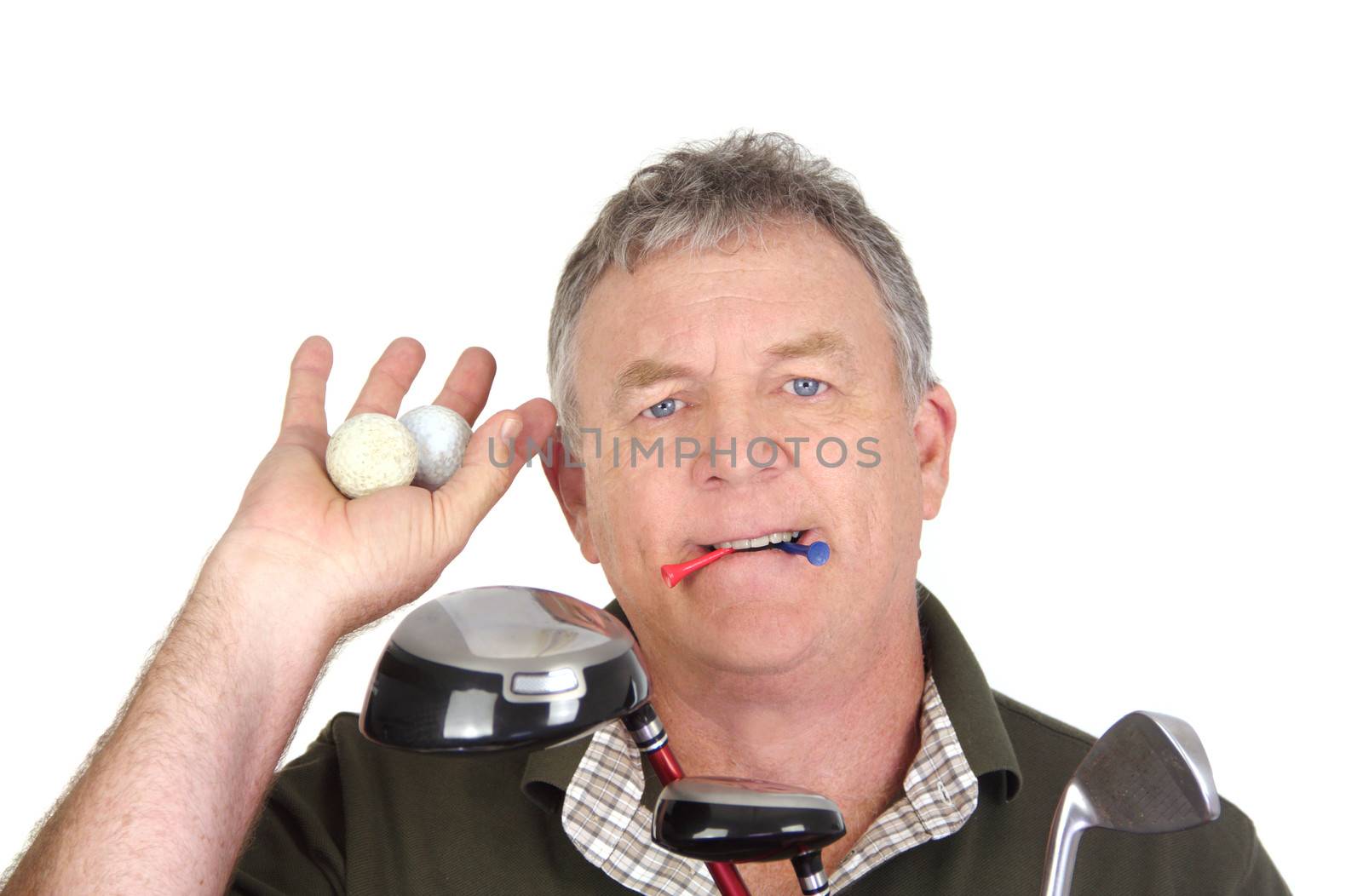 Middle aged golf player holding two used golf balls with tees in mouth.