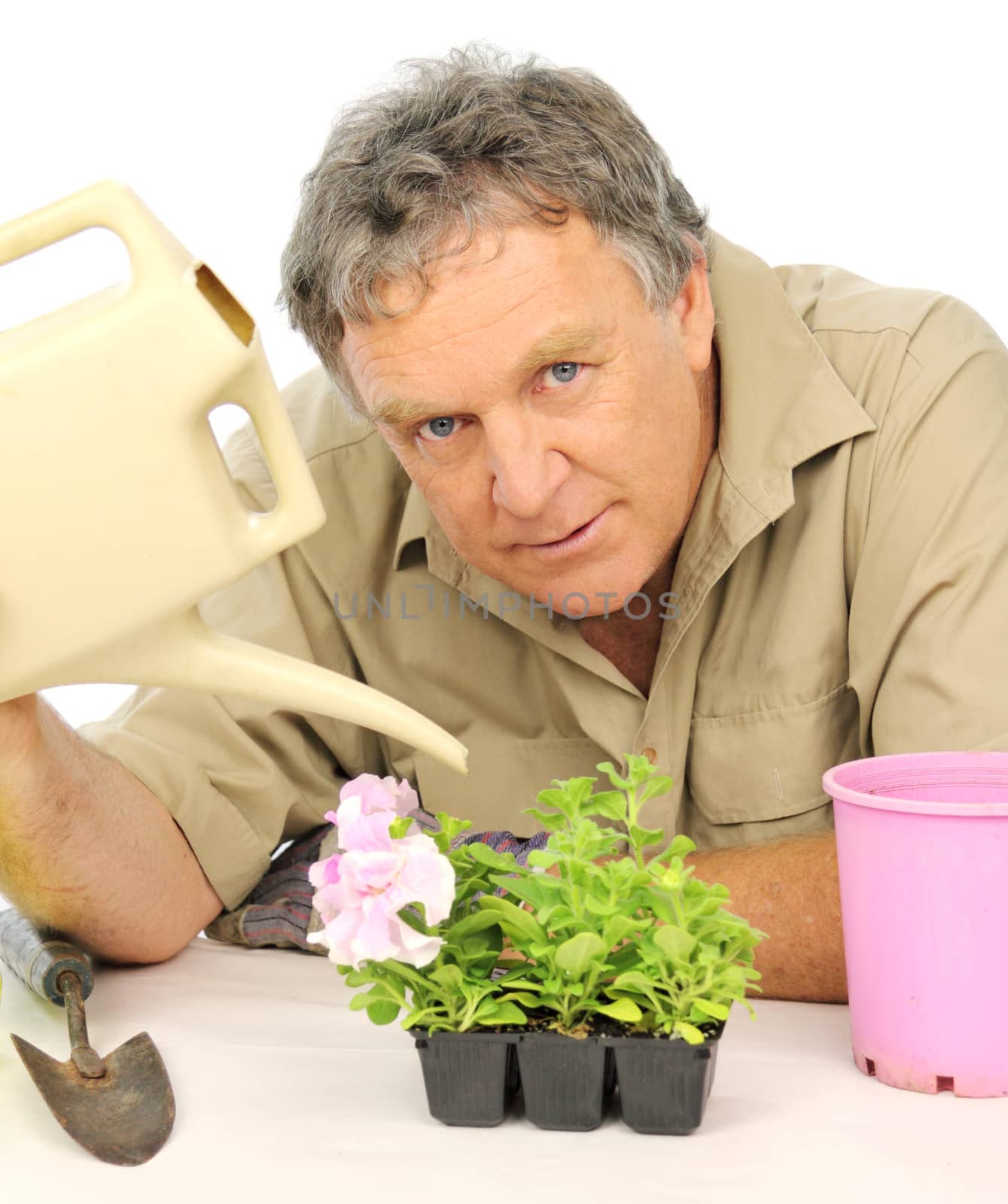 Nurseryman watering seedlings with a watering can.