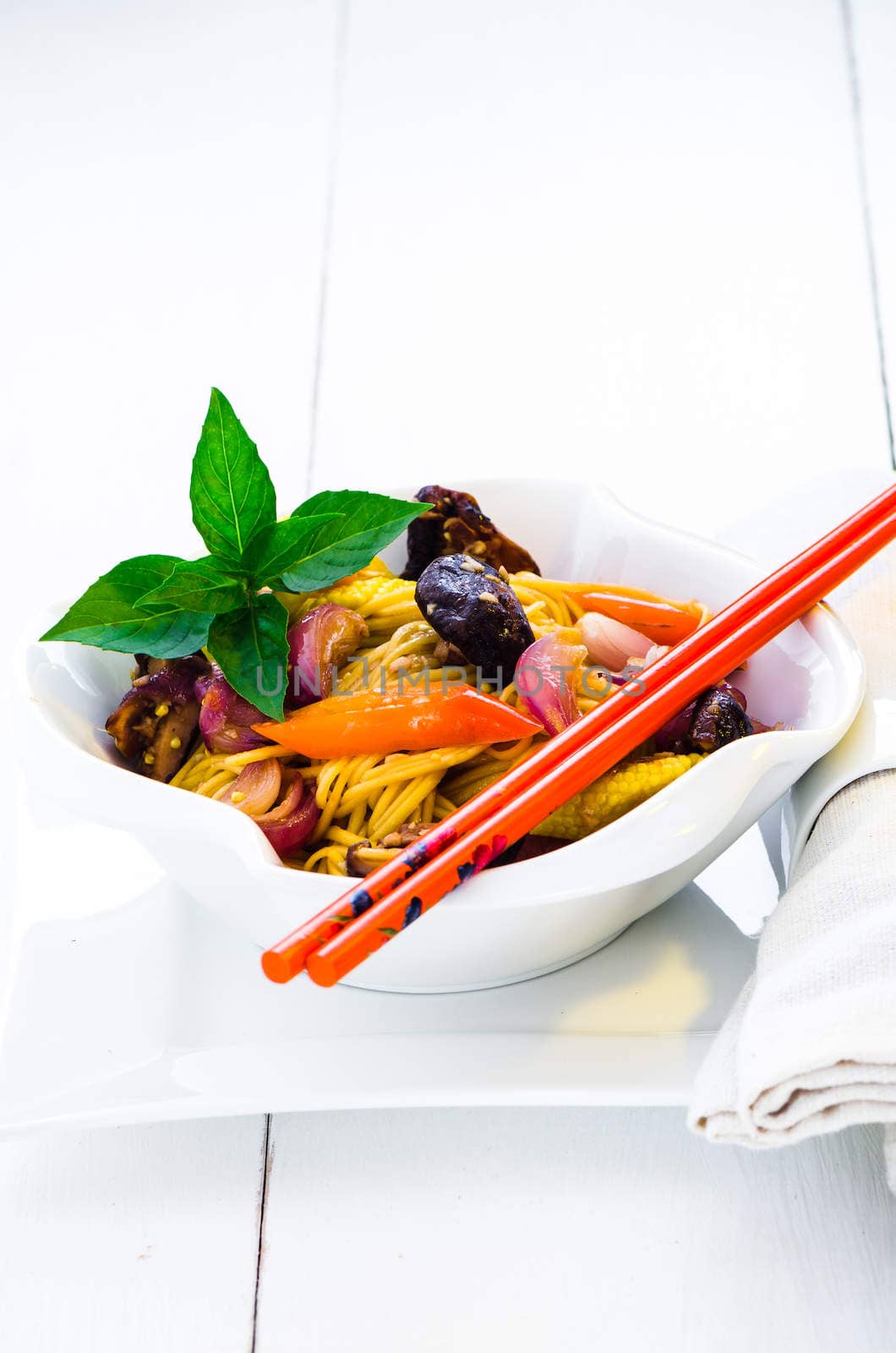 a bowl with chinese vegetarian noodles on white background