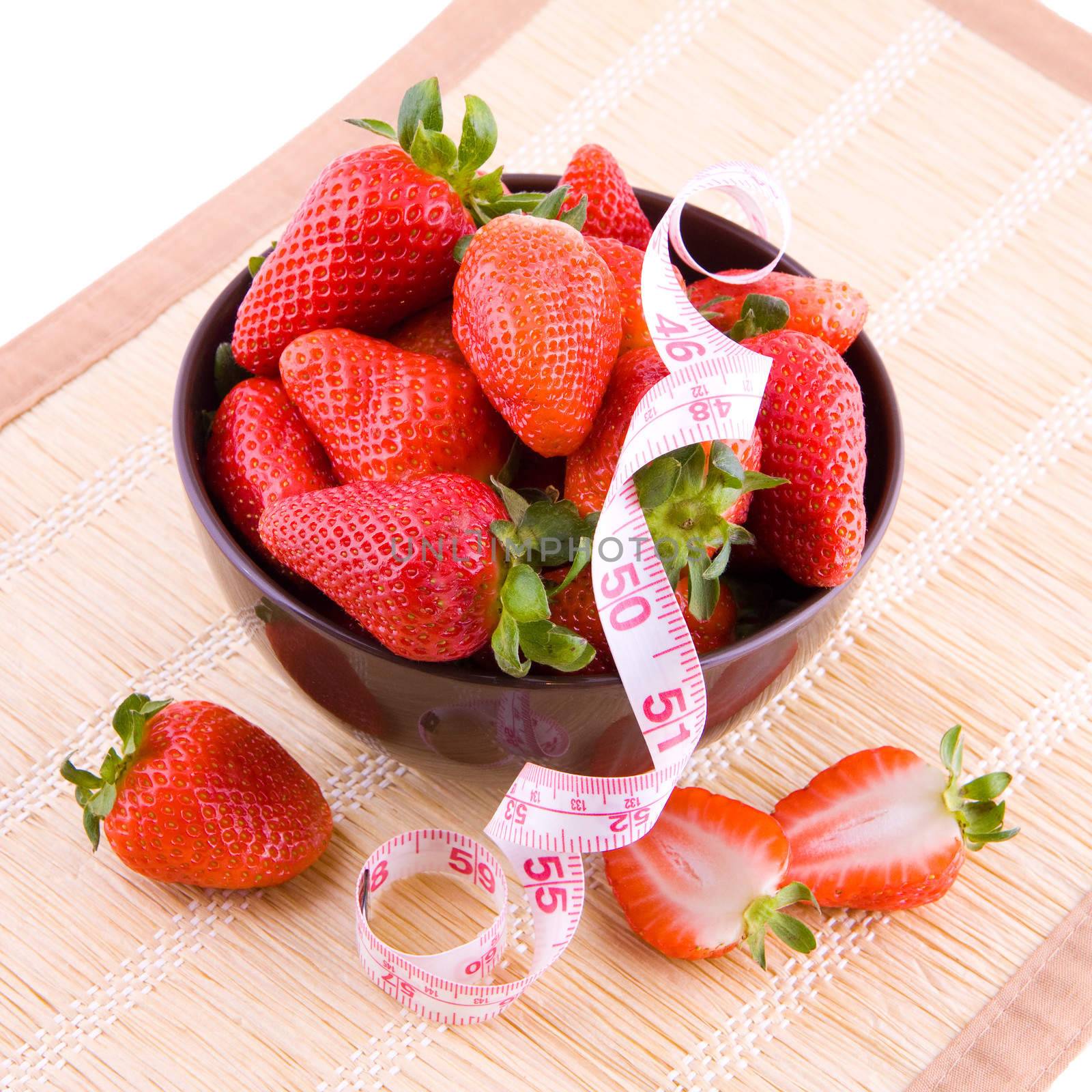 Fresh strawberries in porcelain bowl and tailor tape