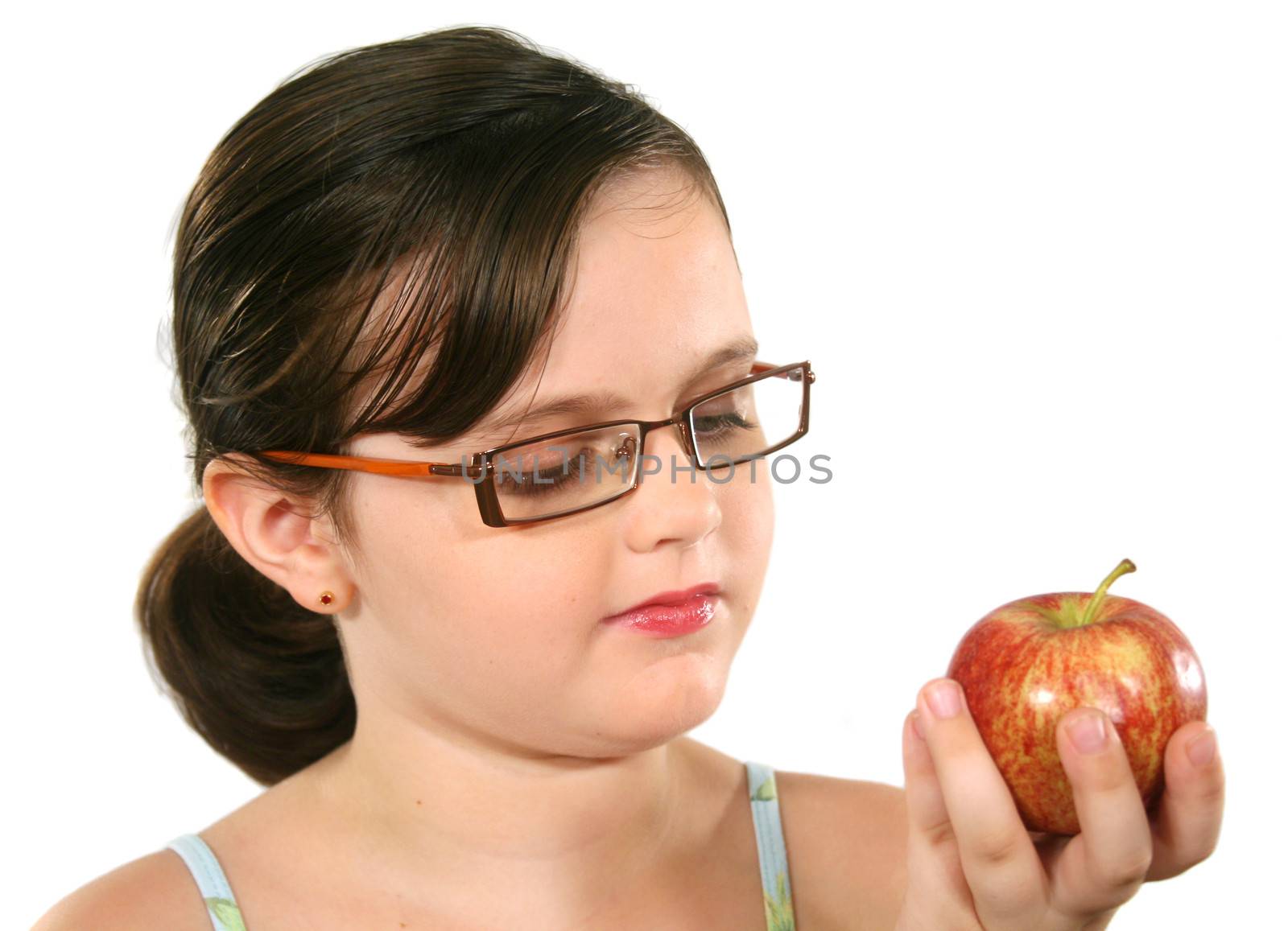 Cute little girl with glasses holding an apple.