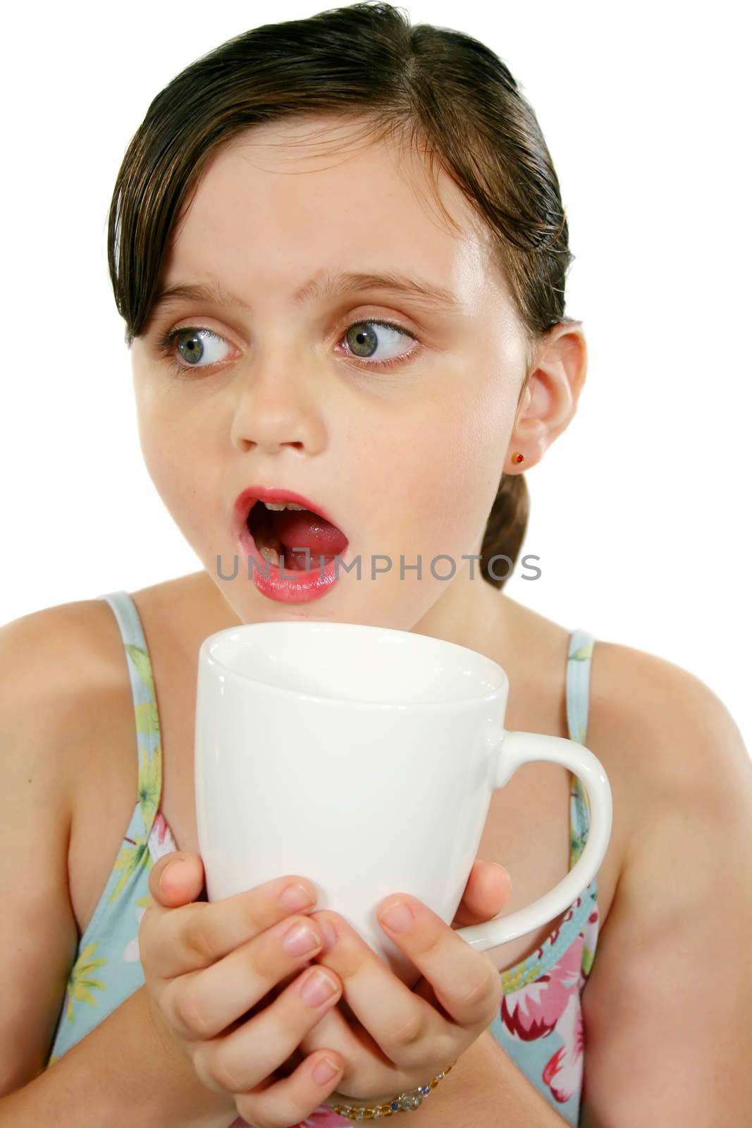 Little girl looks surprised holding a coffee mug.