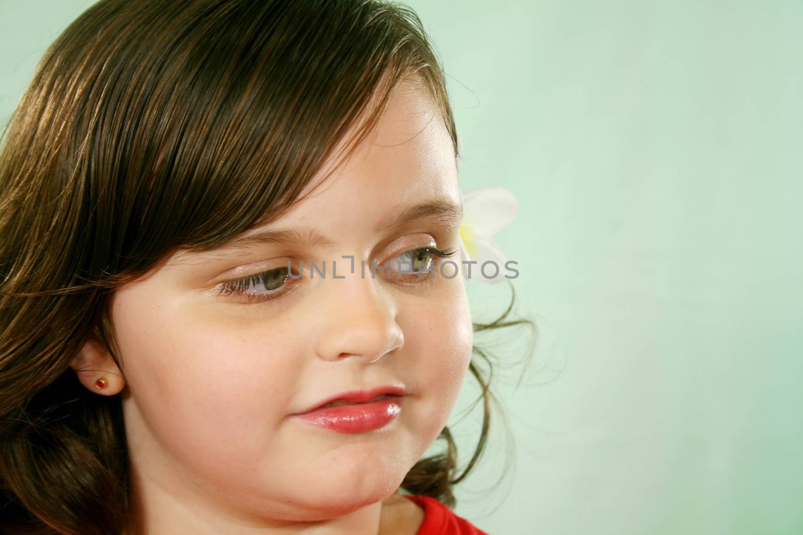 Three quarter profile close up of little girl looking camera right.