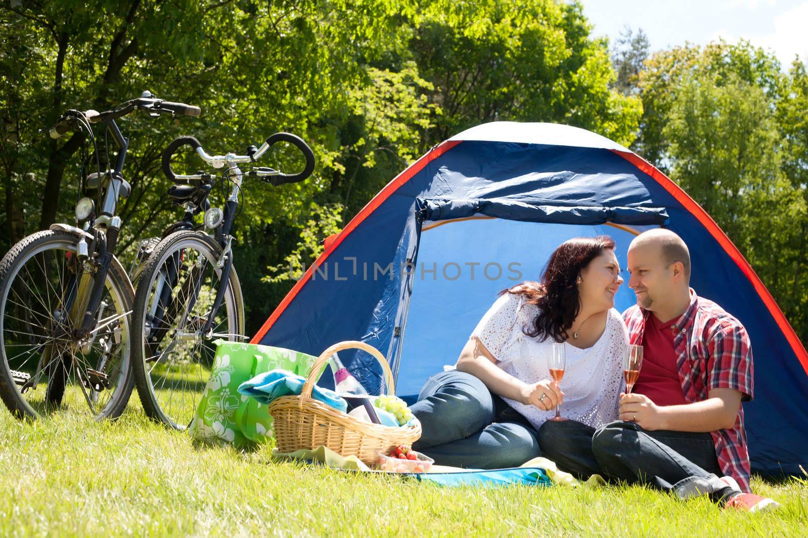 Happy couple on a camping drinking prosecco by DNFStyle