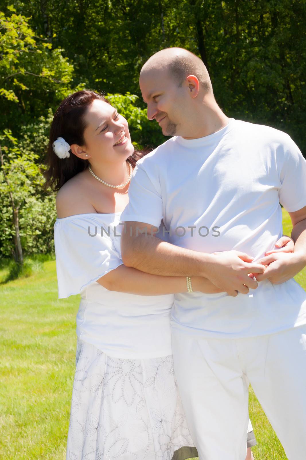 Happy young couple dressed white in the nature