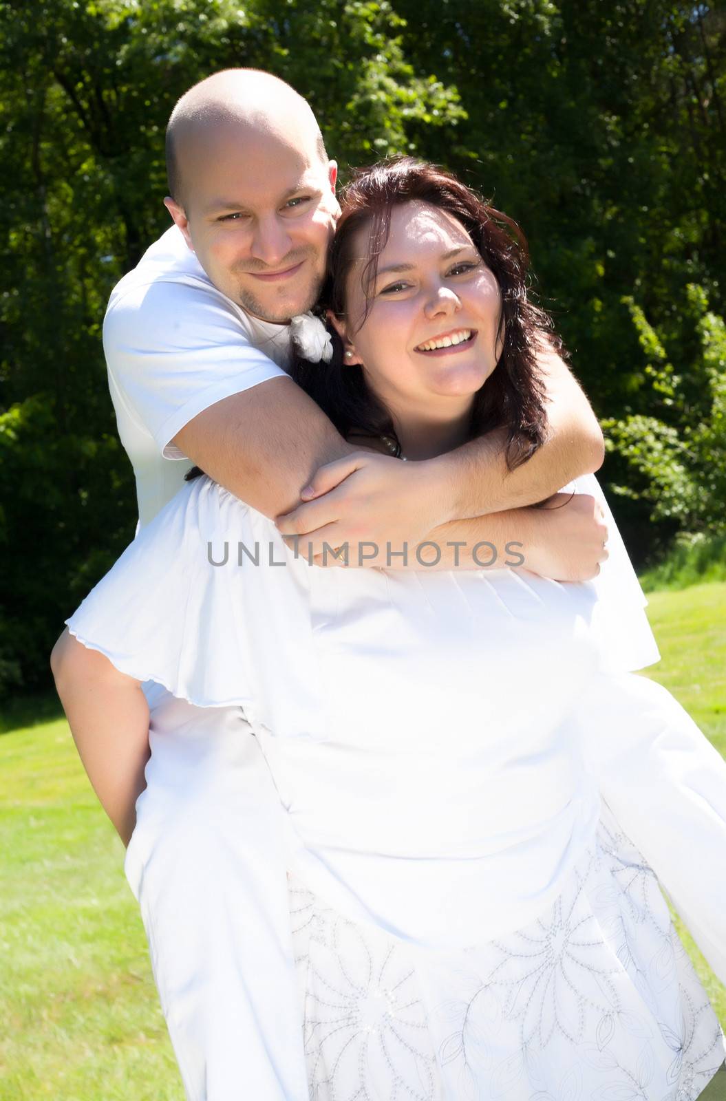 Happy young couple dressed white in the nature