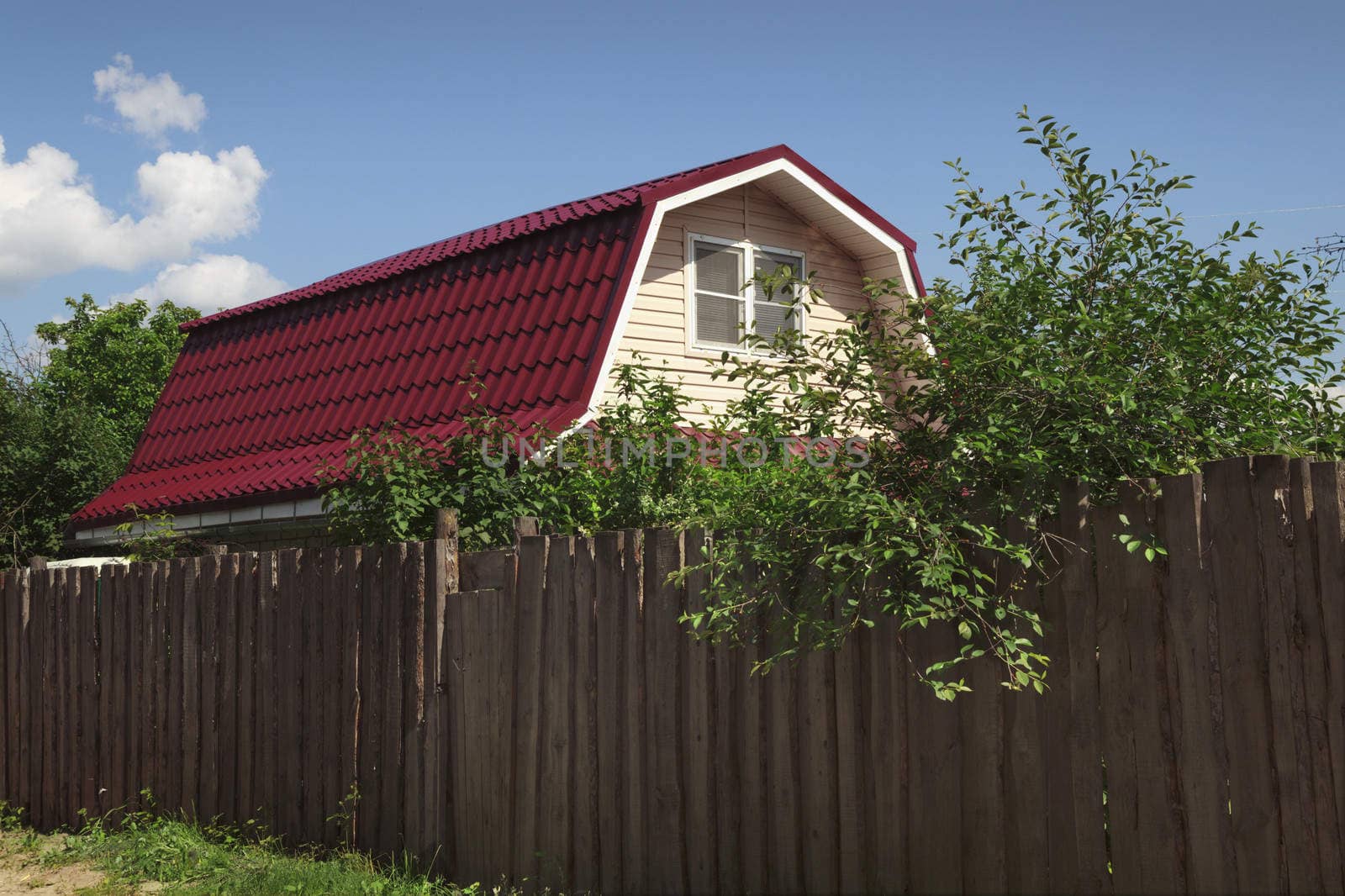 Small country house hidden behind a high fence