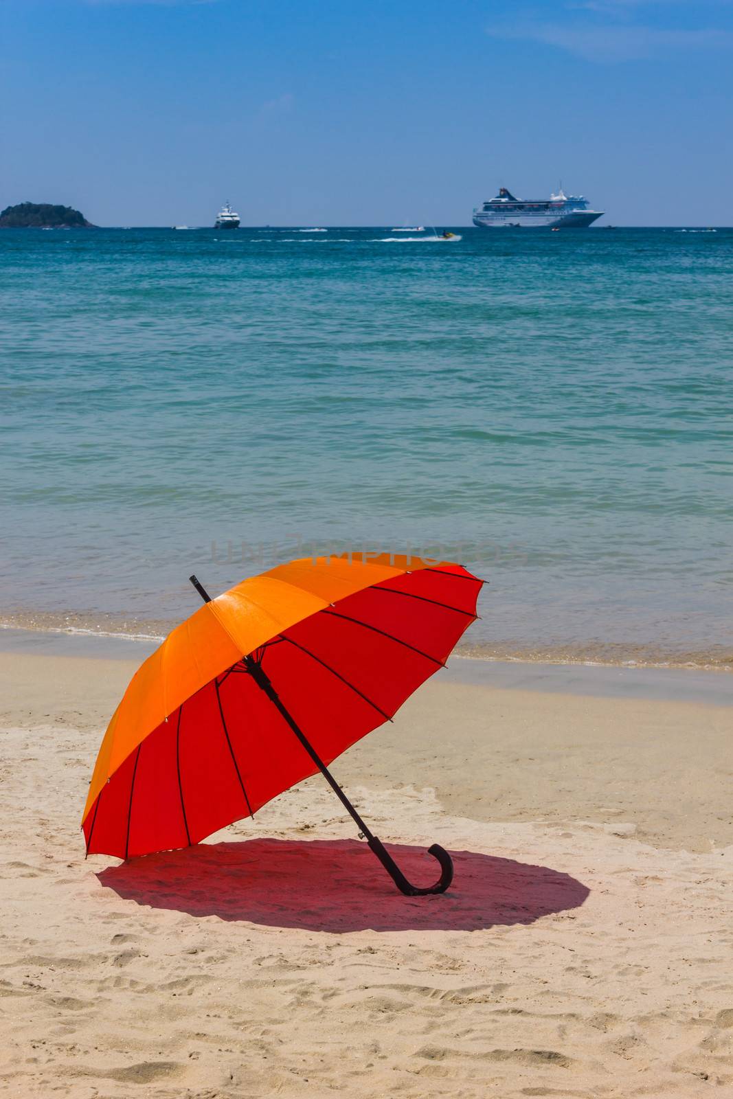 Orange umbrella on the beach in Thailand