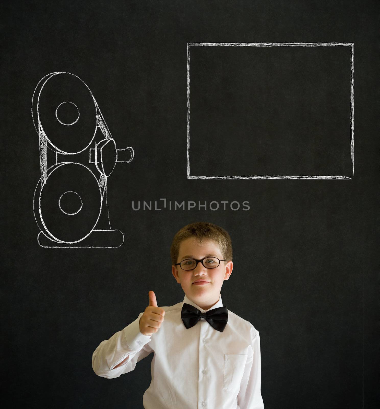 Thumbs up boy dressed up as business man with retro chalk film projector on blackboard background