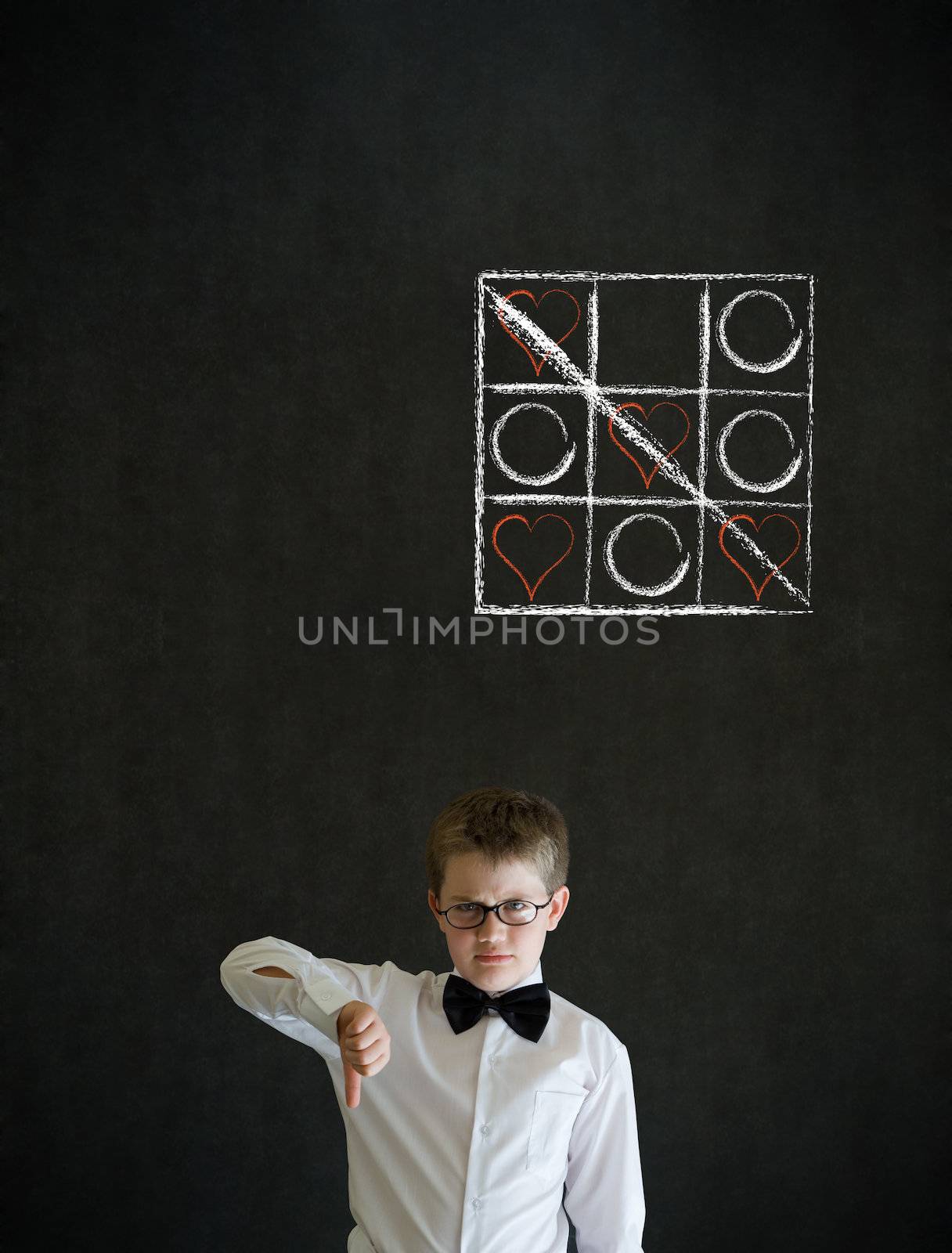 Thumbs down boy dressed up as business man with chalk tic tac toe love valentine concept on blackboard background