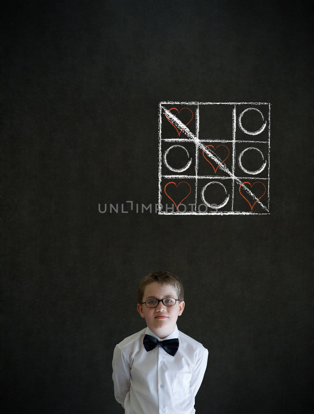 Thinking boy dressed up as business man with chalk tic tac toe love valentine concept on blackboard background