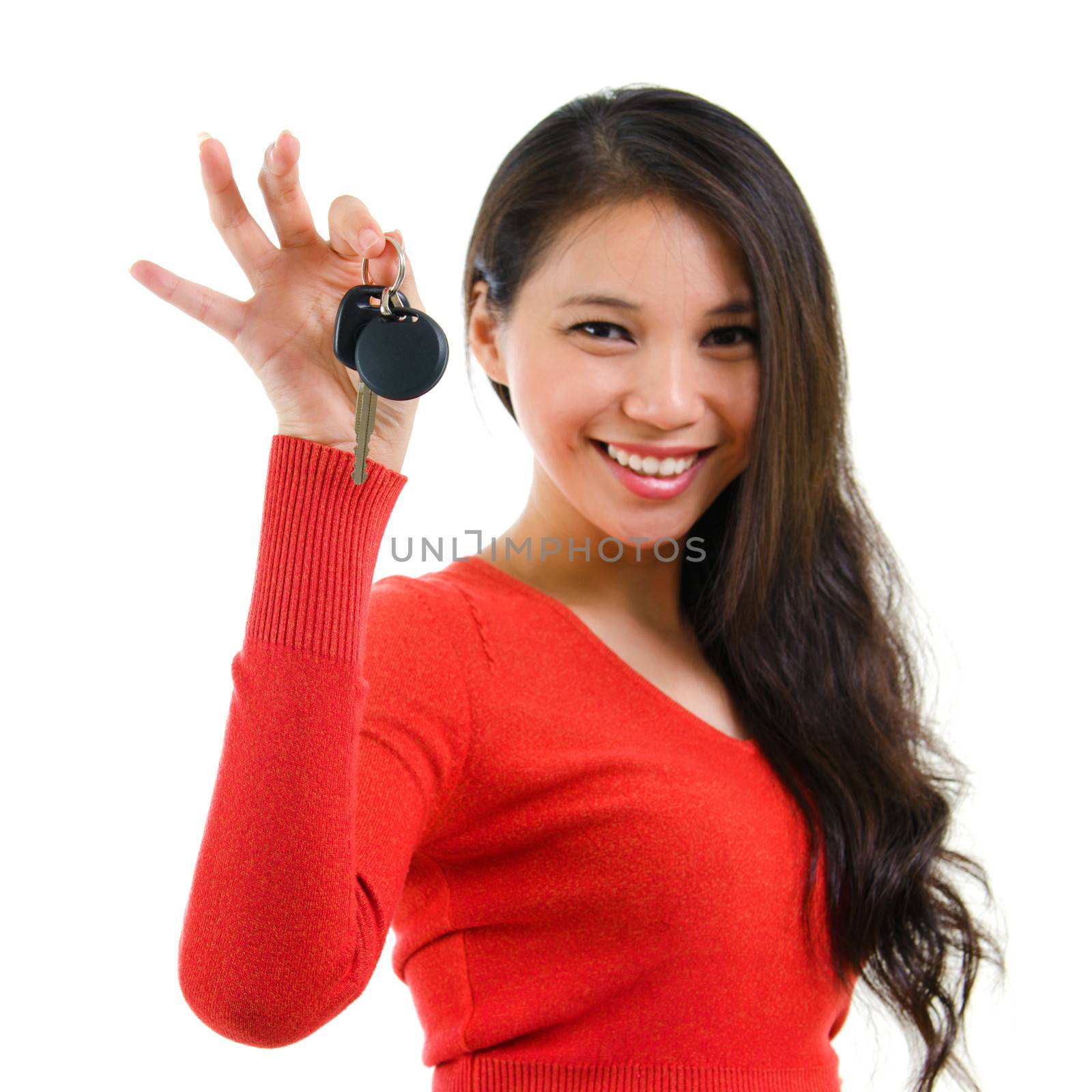 Young woman holding her first own car key isolated on white background. Beautiful mixed race Caucasian Southeast Asian woman model.