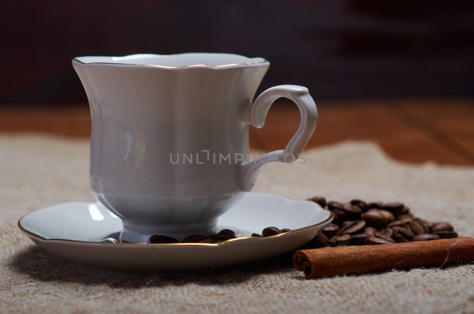 Coffee cup with cinnamon and coffee beans background