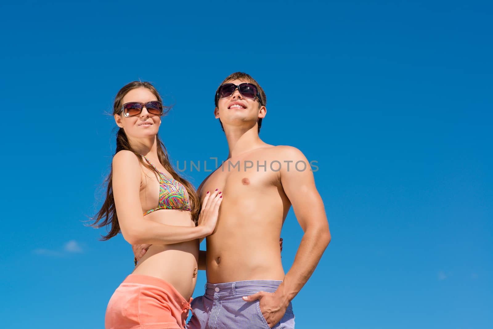 Young couple hugging on a background of blue sky, hold together honeymoon