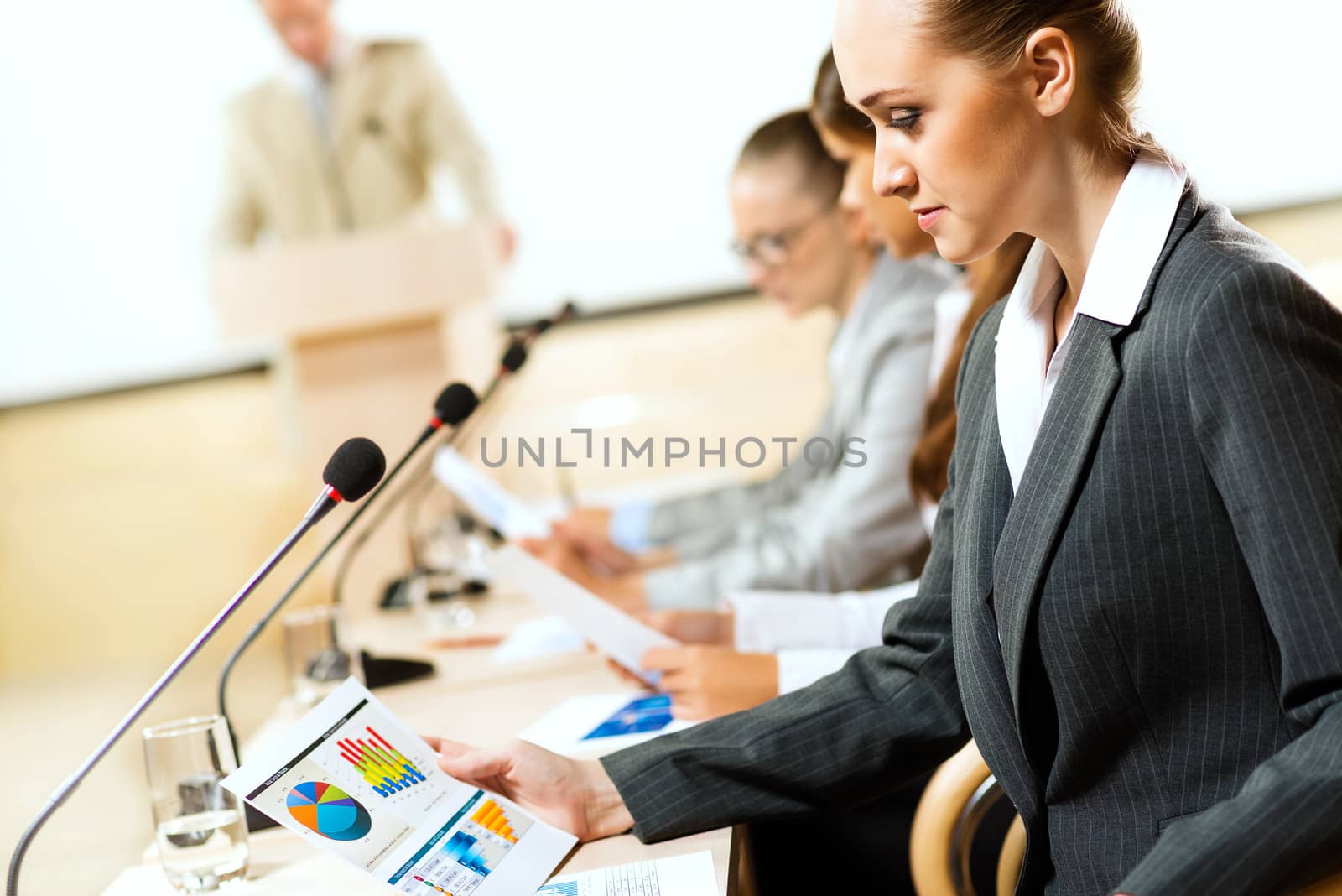 businessmen communicate at the conference, sitting at the table, on the table microphones and documents