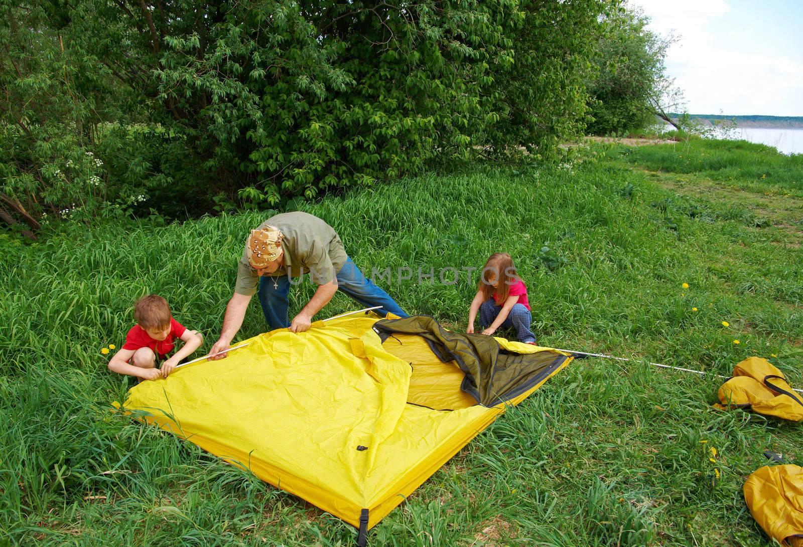  Father with children installing their tent by Fanfo