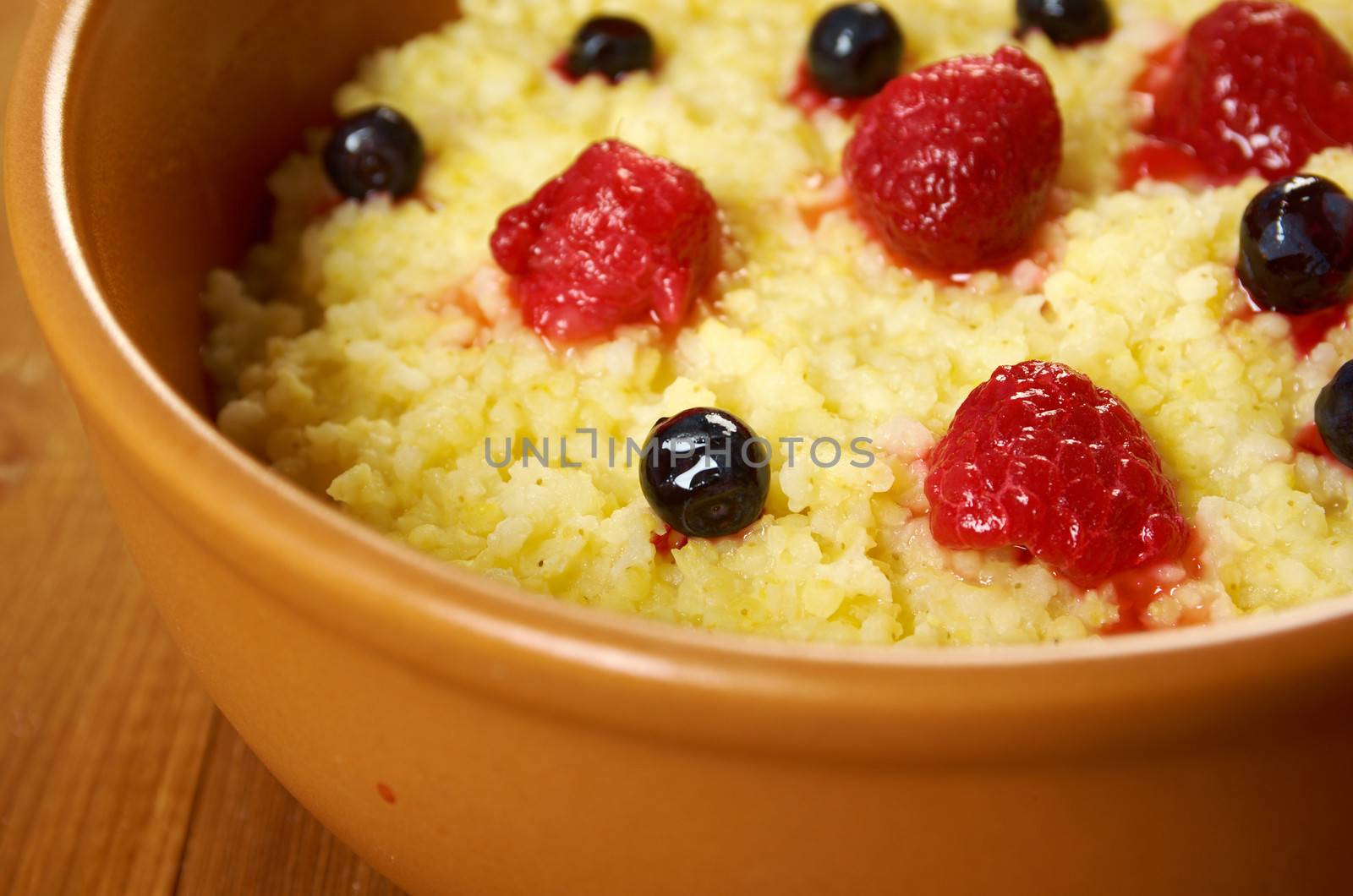 Millet porridge with berry in brown bowl on table