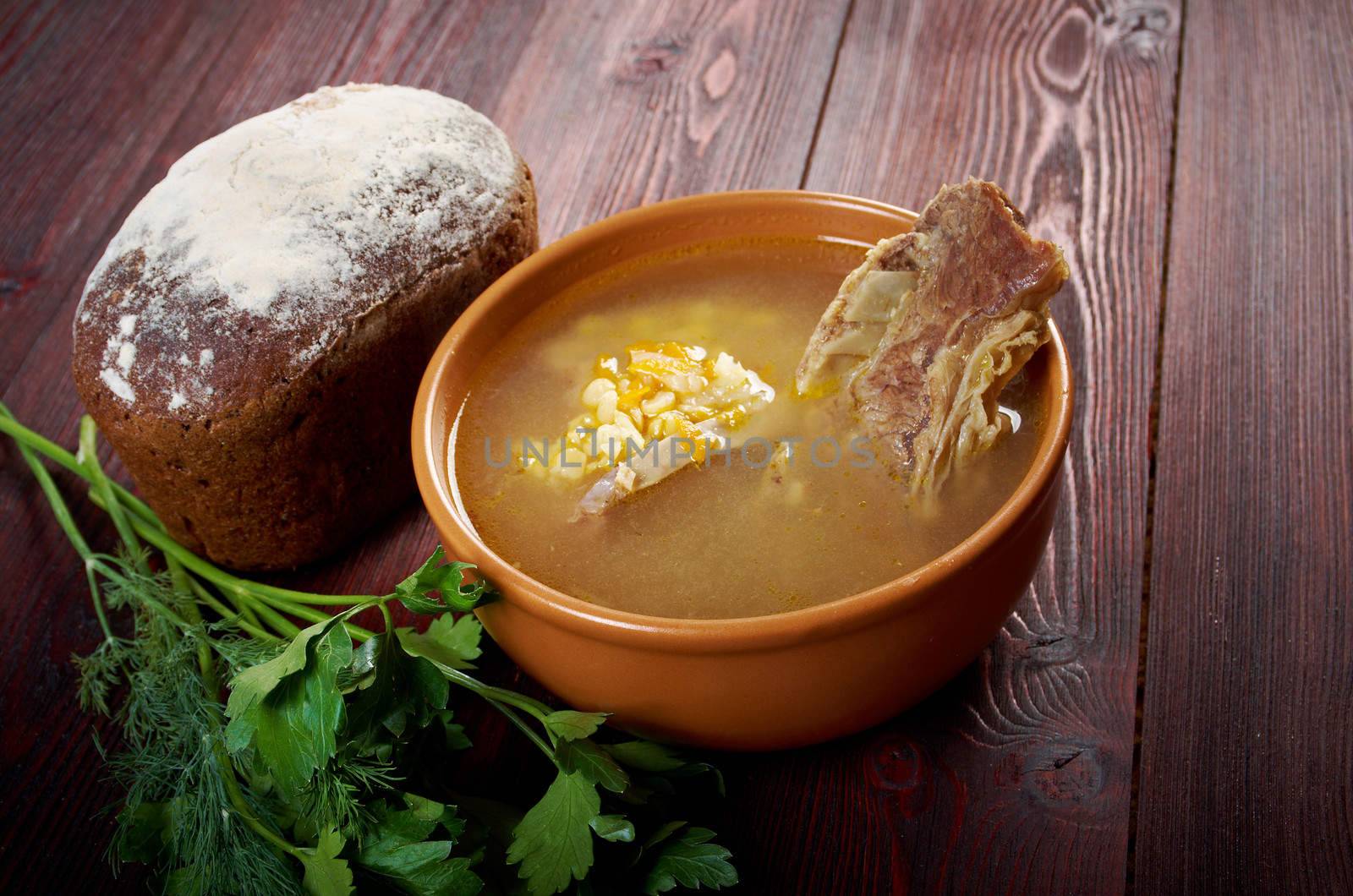 Pea soup with beef ribs  and farmhouse bread,edible greens .farmhouse kitchen