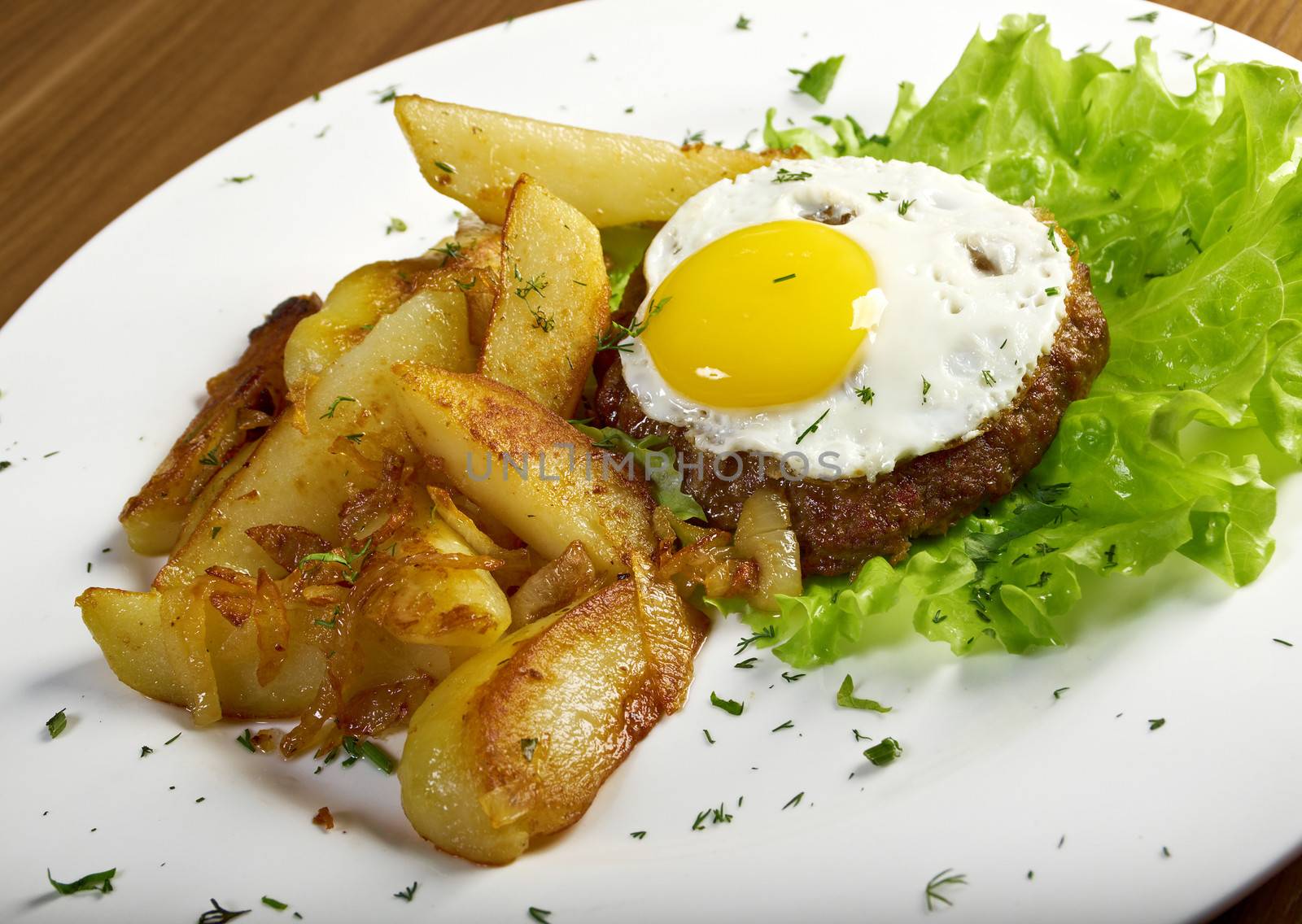 A dinner of a T-bone or porterhouse steak, served with baked potat