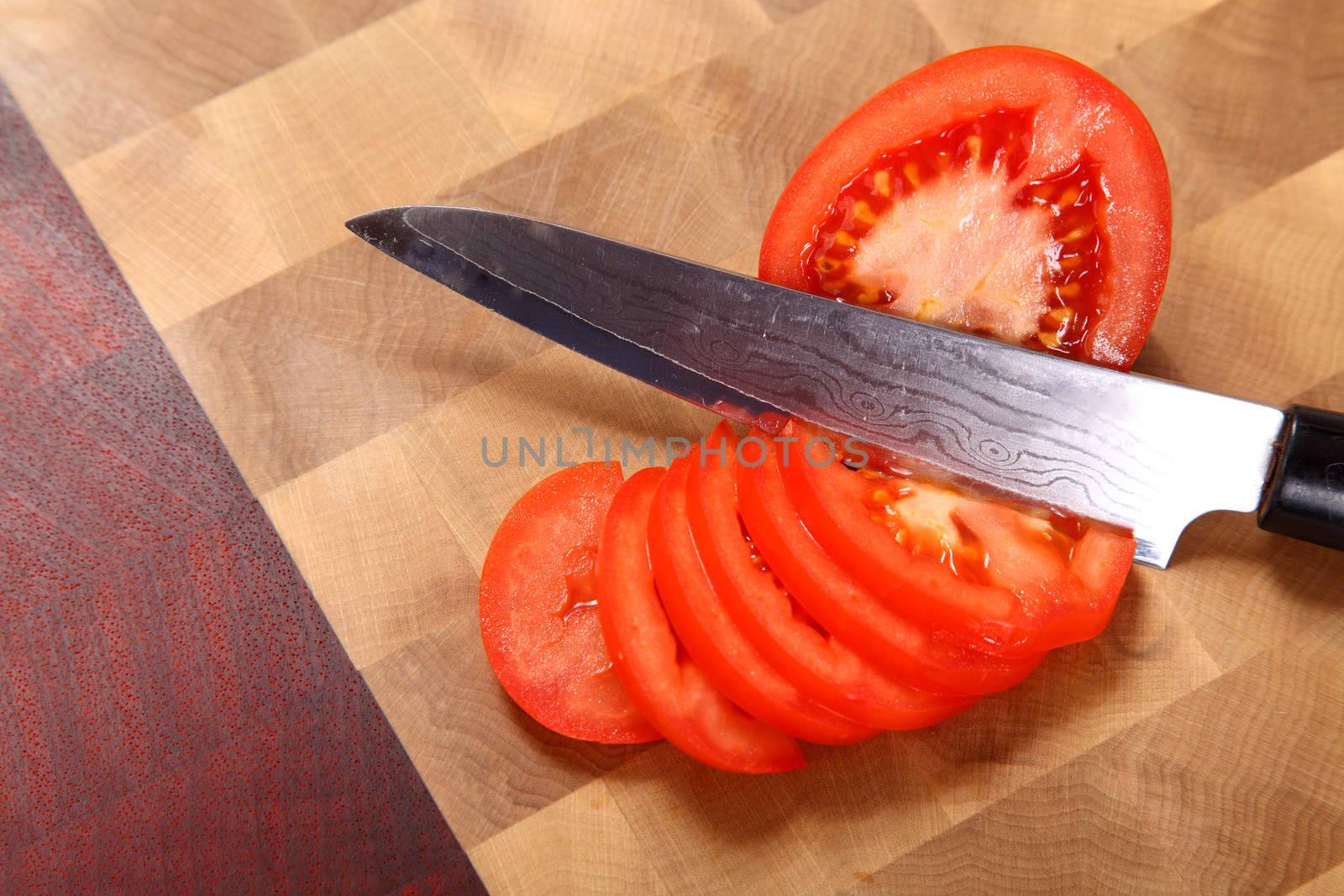 the tomato cut by means of a knife on a chopping board
