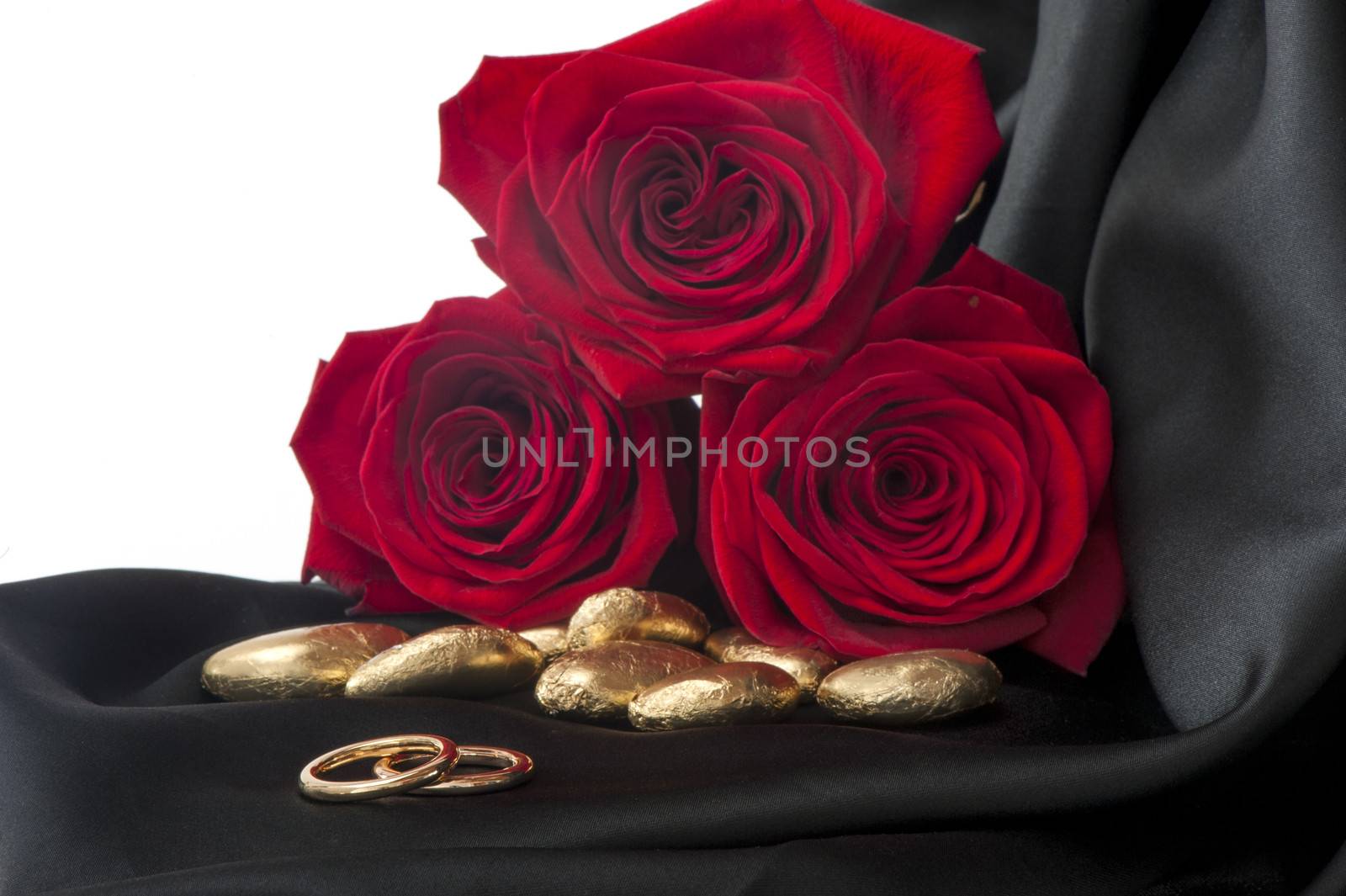 a  candy, roses and gold wedding rings 