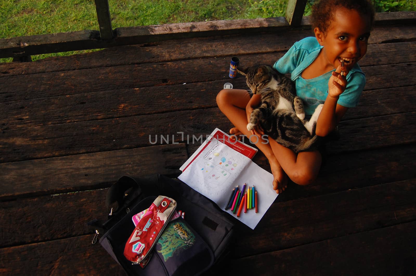 Girl plays with cat, Papua New Guinea