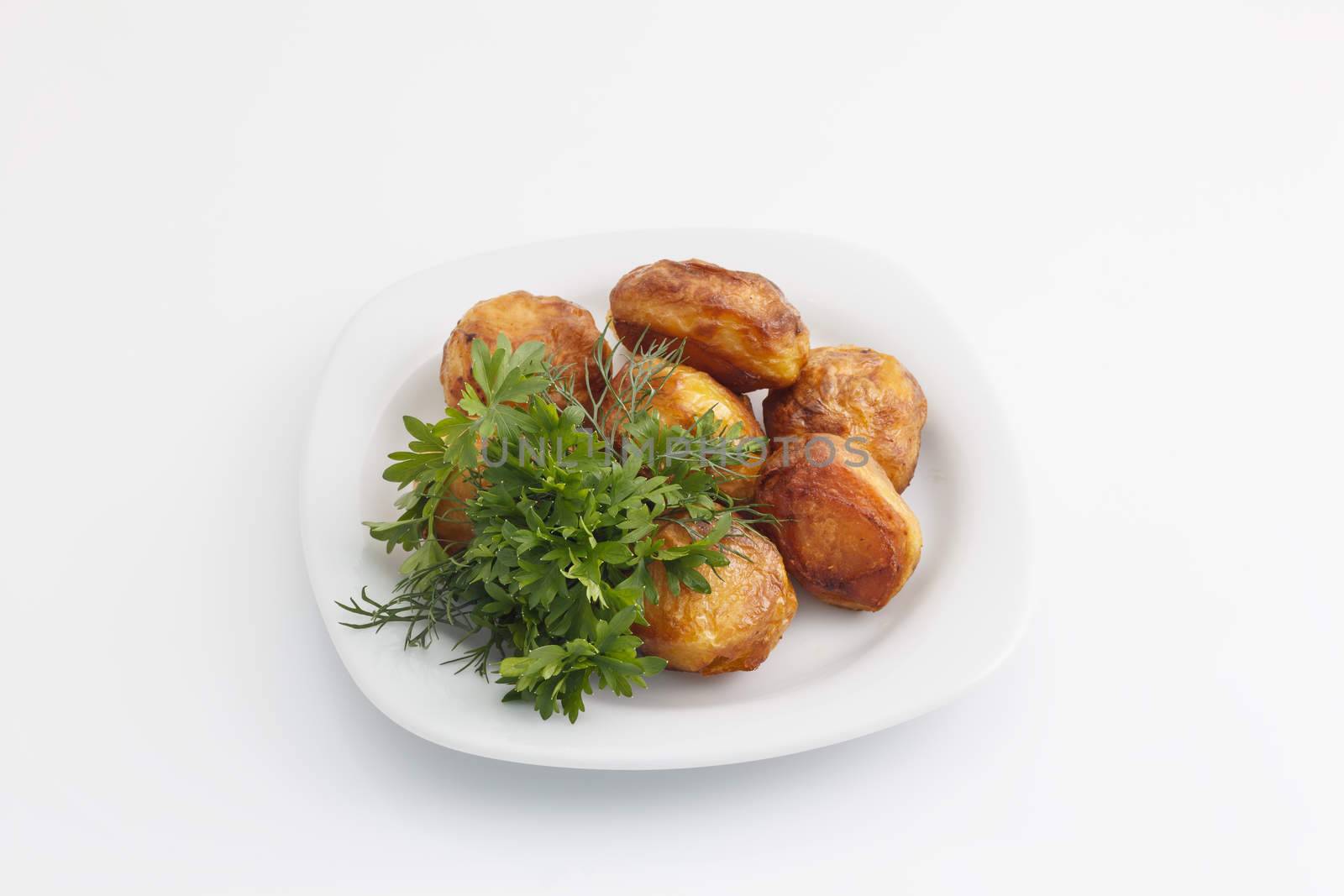 Baked potatoes with dill and parsley on a white background