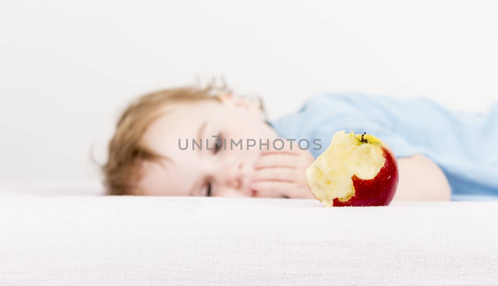 red apple with blurred, sleeping child in background