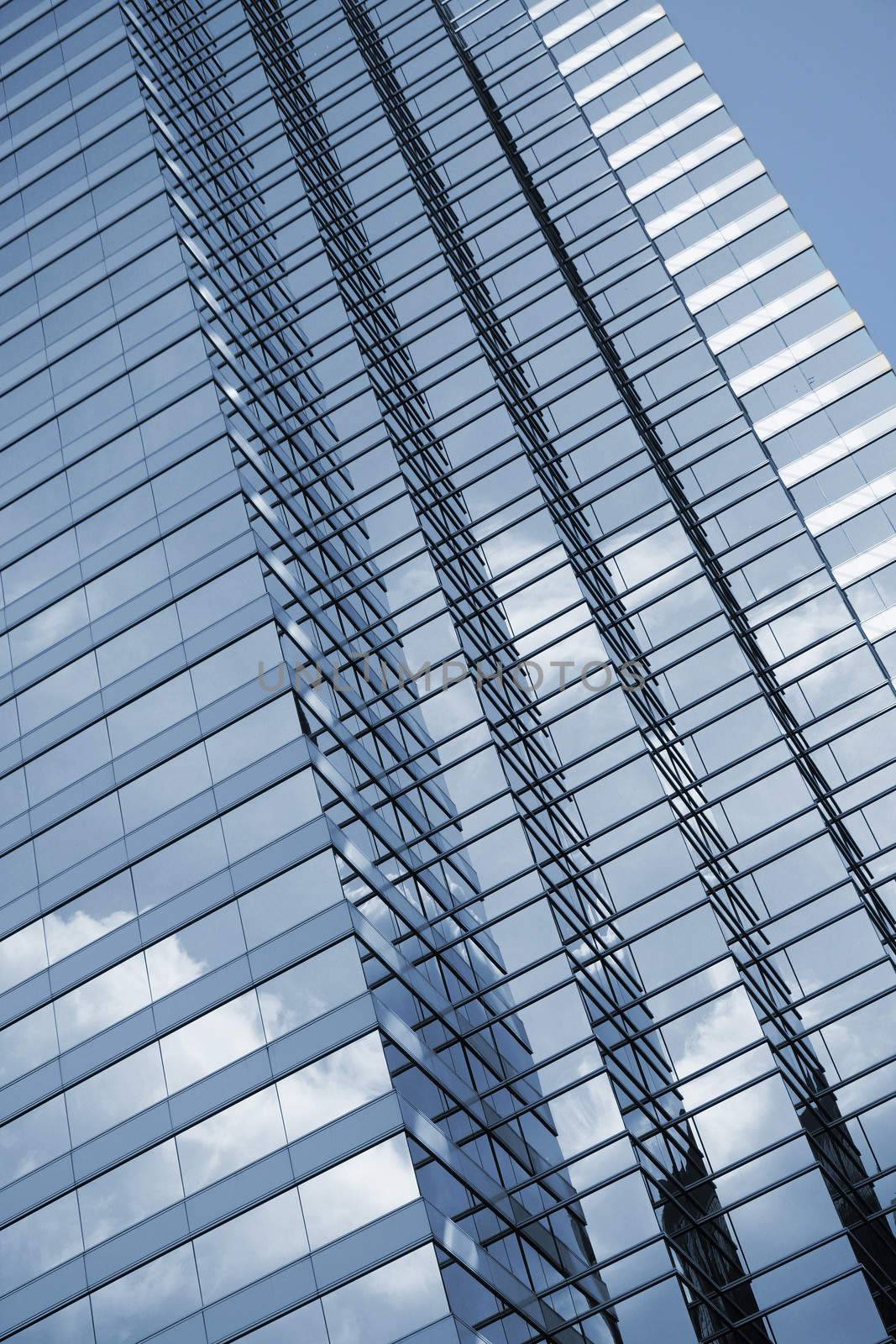 Modern skyscraper exterior with glass and reflection in daytime.