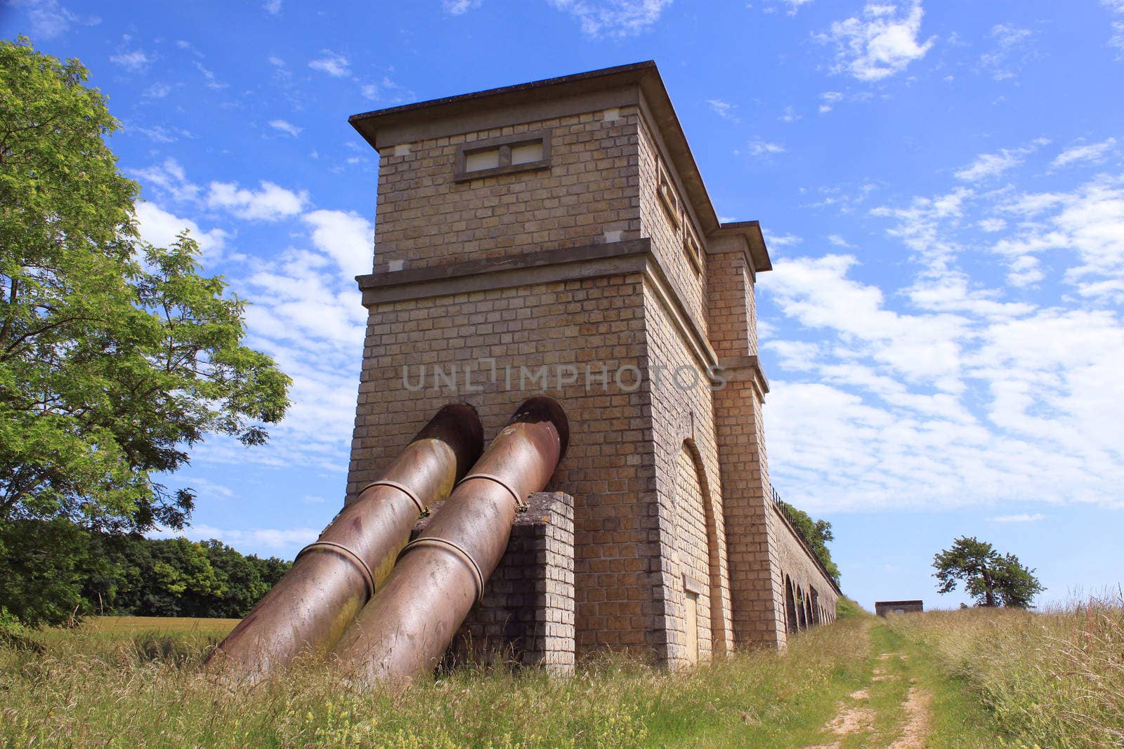a medieval old pipeline in a field on blue sky background