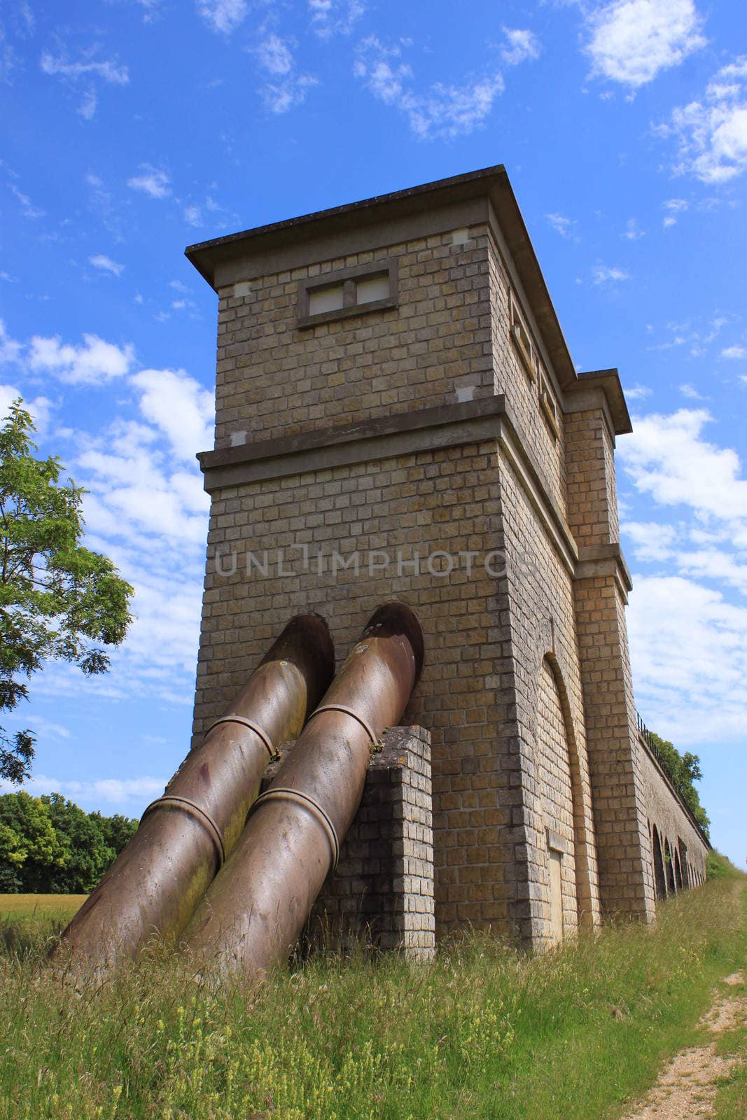 a medieval old pipeline in a field on blue sky background