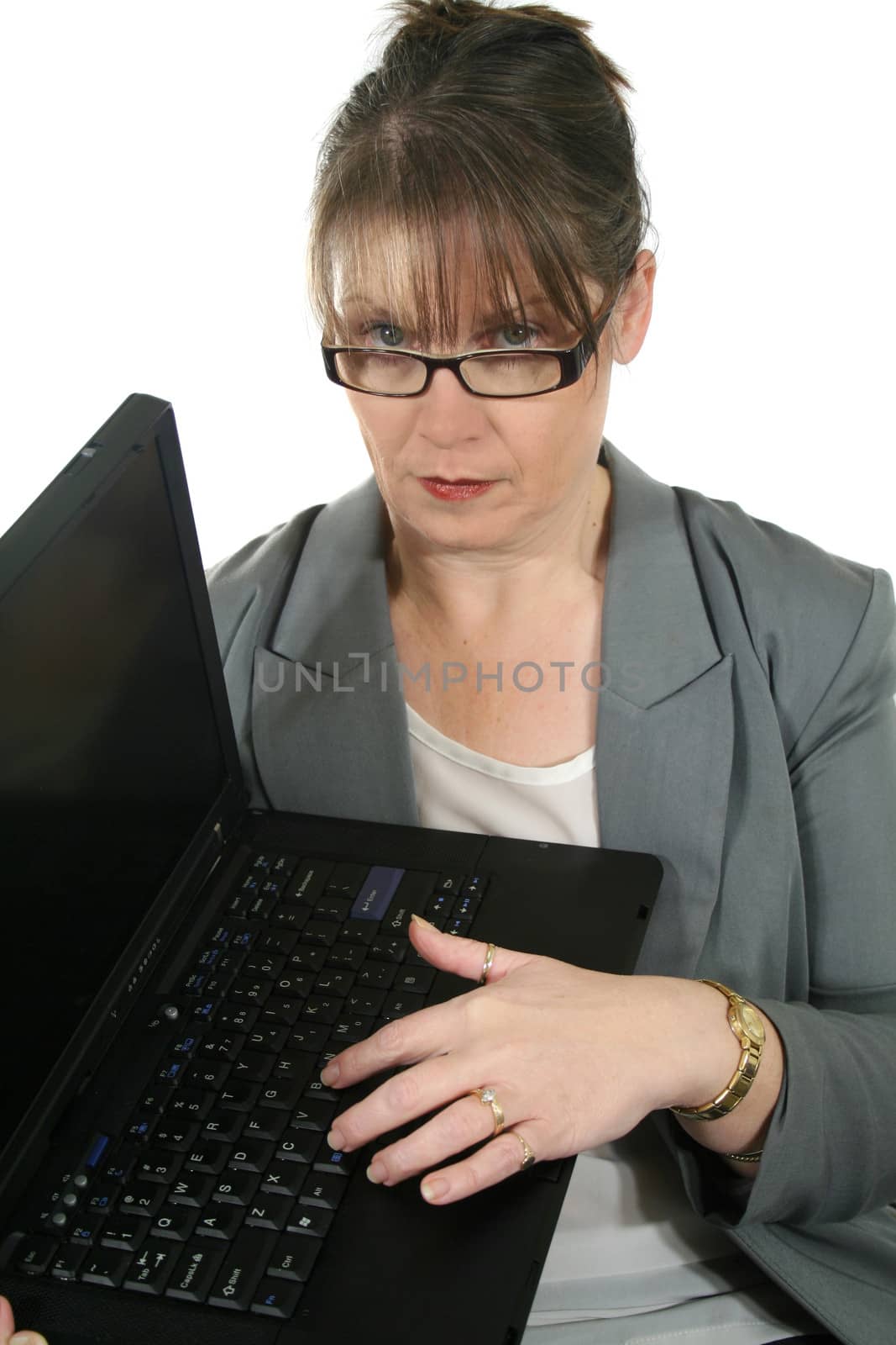 Stern businesswoman with glasses and laptop staring.