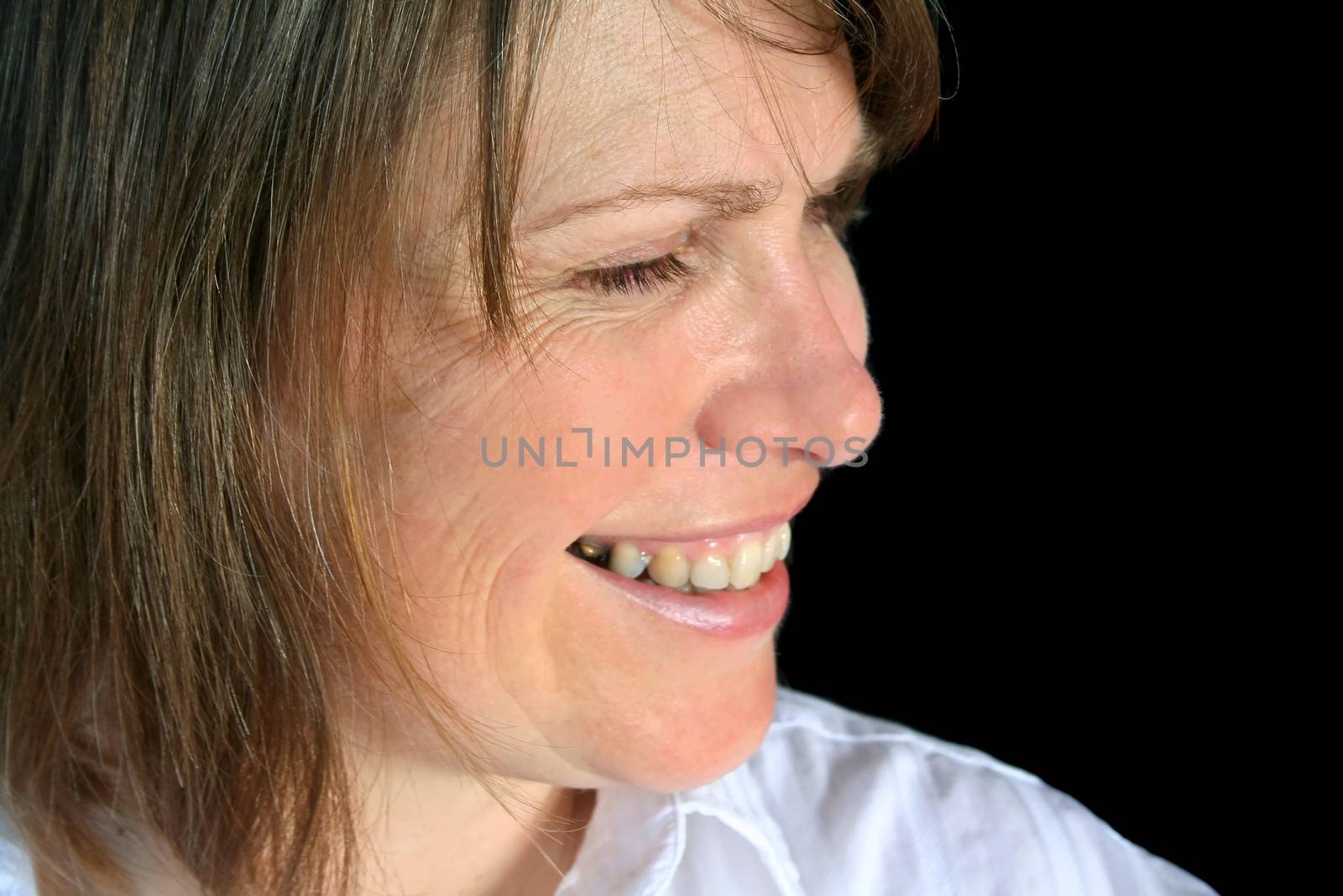 Profile close up of a middle aged female smiling.