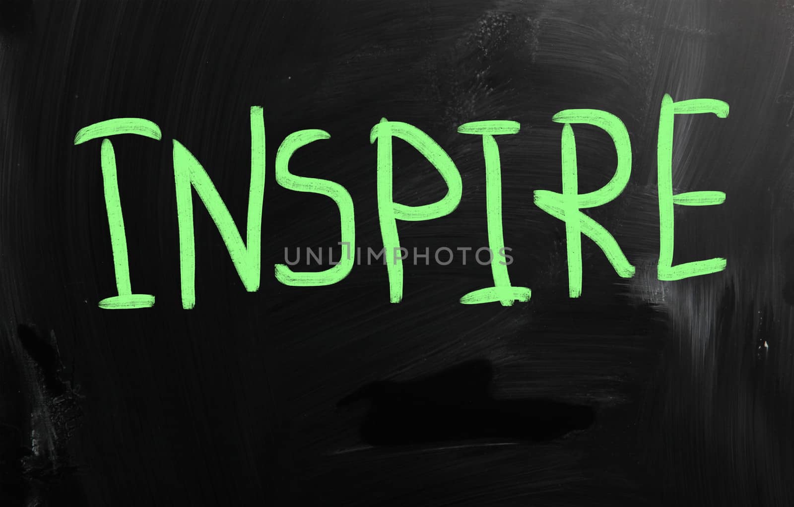 "Inspire" handwritten with white chalk on a blackboard