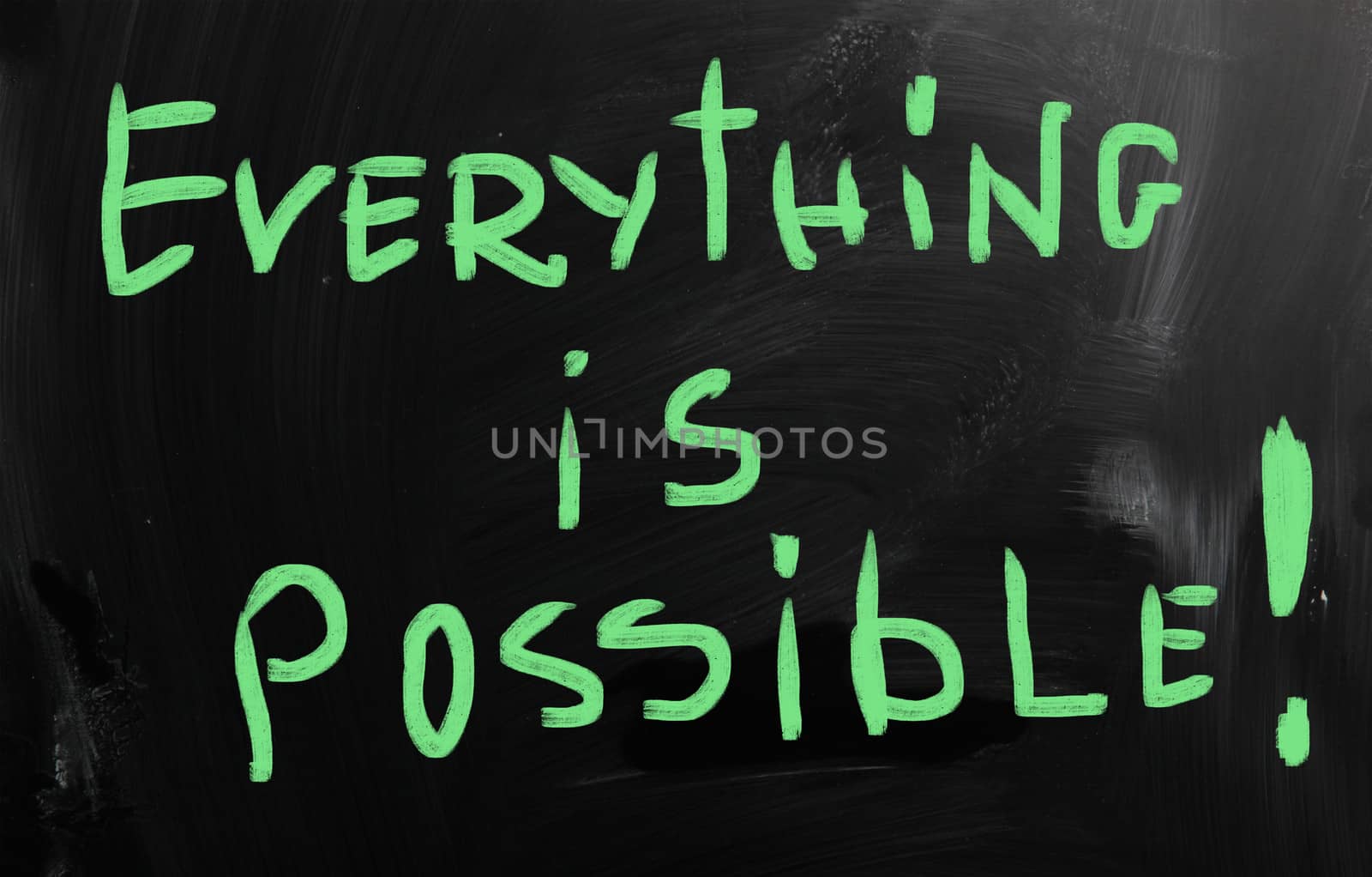 "Everything is possible" handwritten with white chalk on a blackboard