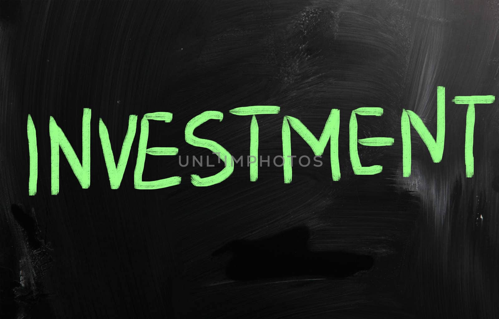 "Investment" handwritten with white chalk on a blackboard