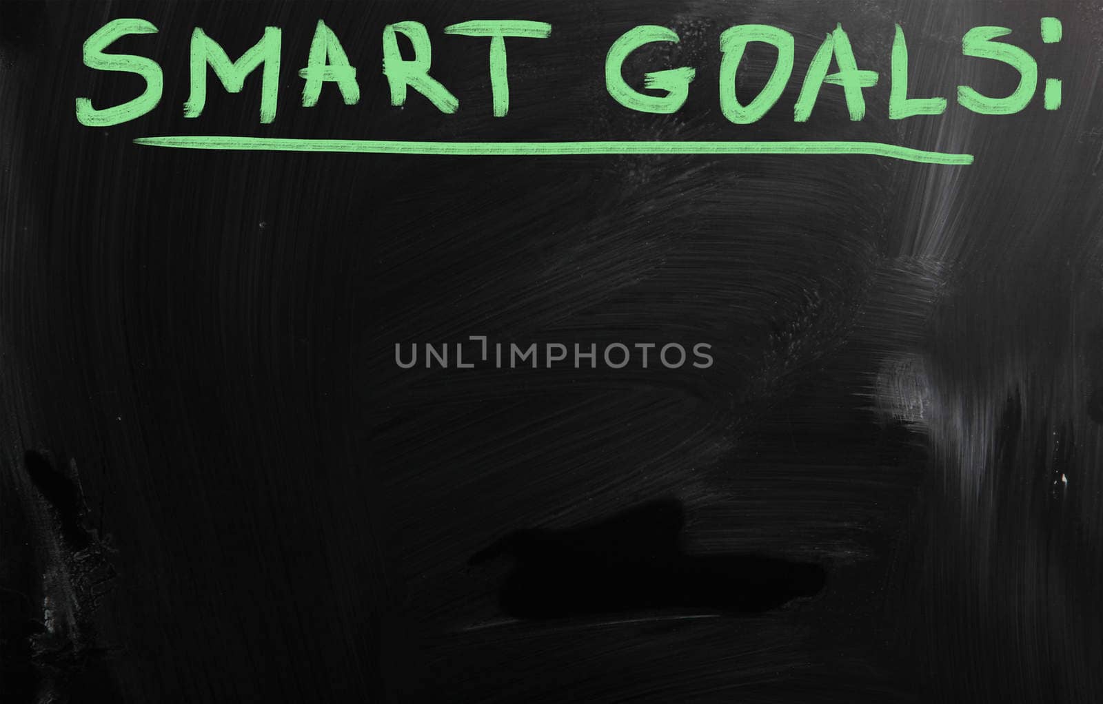 "Smart goals" handwritten with white chalk on a blackboard