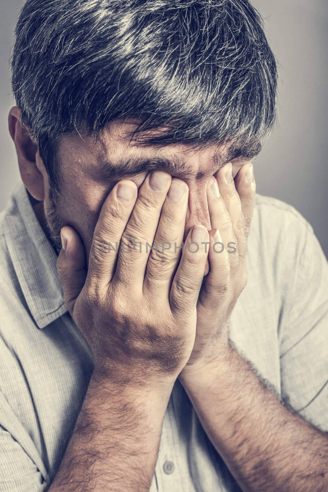 man covered his face with his hands