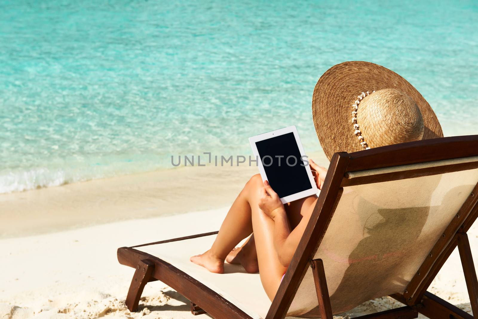Young woman with tablet pc at the beach by haveseen