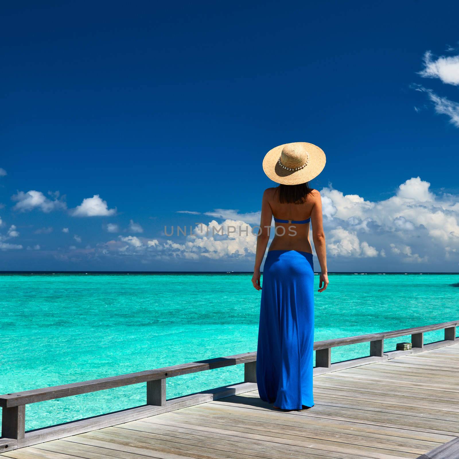 Woman on a tropical beach jetty at Maldives