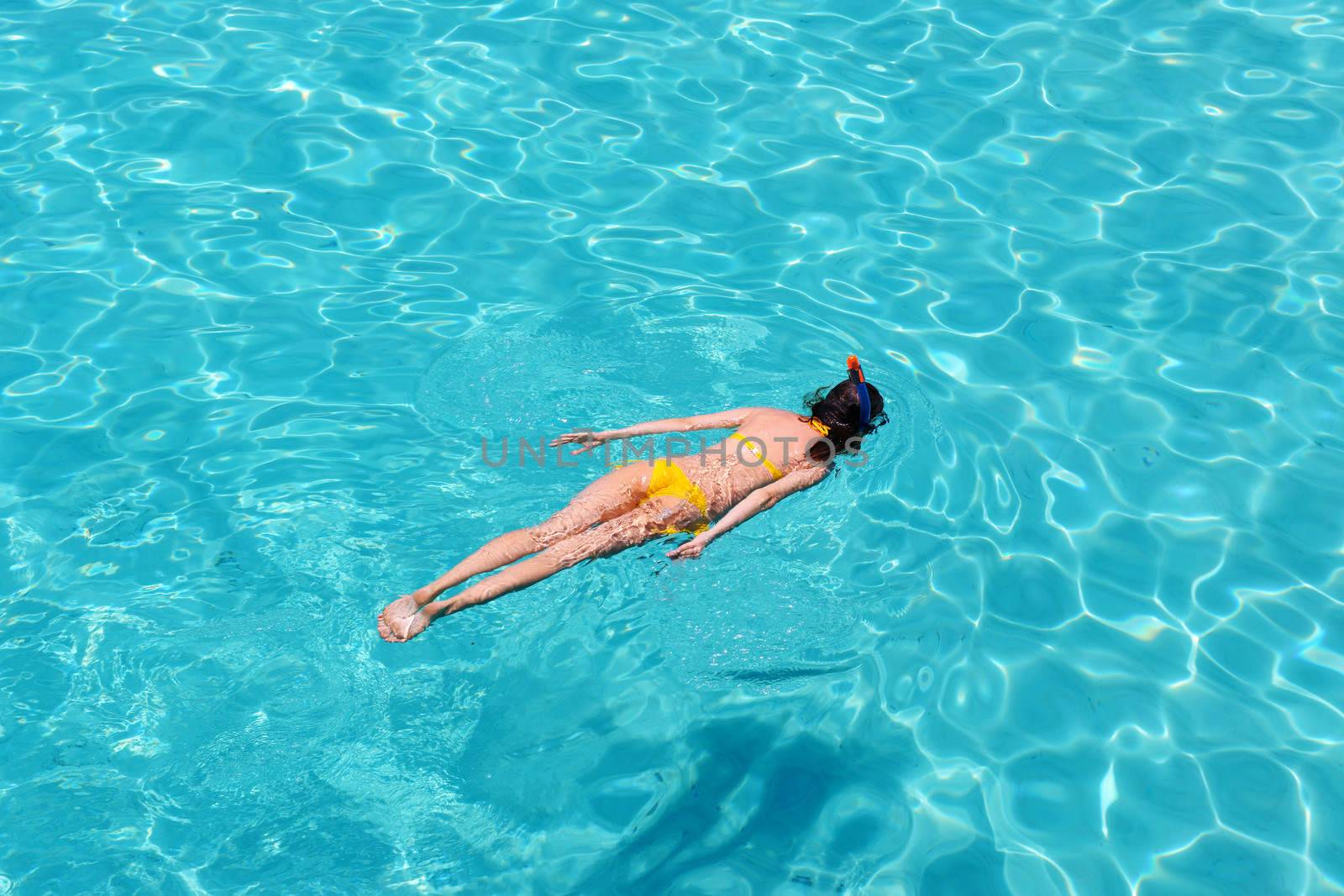 Woman snorkeling in crystal clear turquoise water at tropical beach