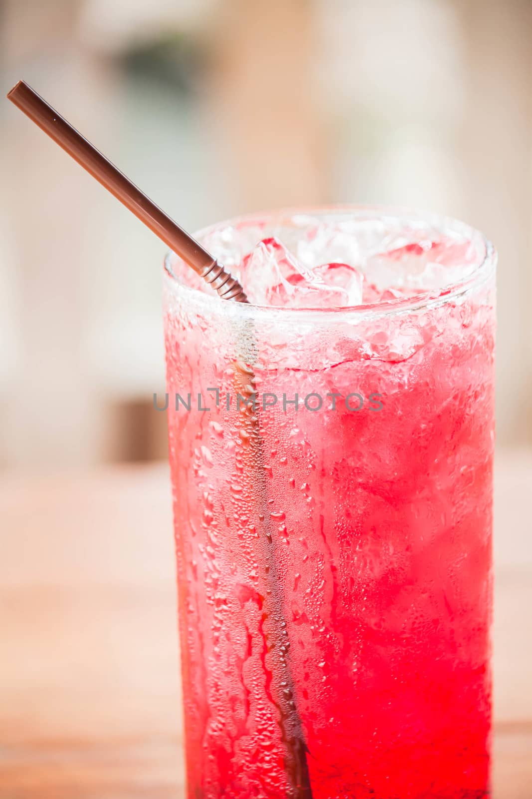 Glass of red drink with iced cubes