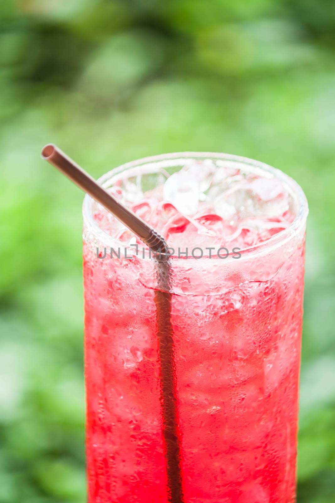 Fresh glass of red drink with iced cubes