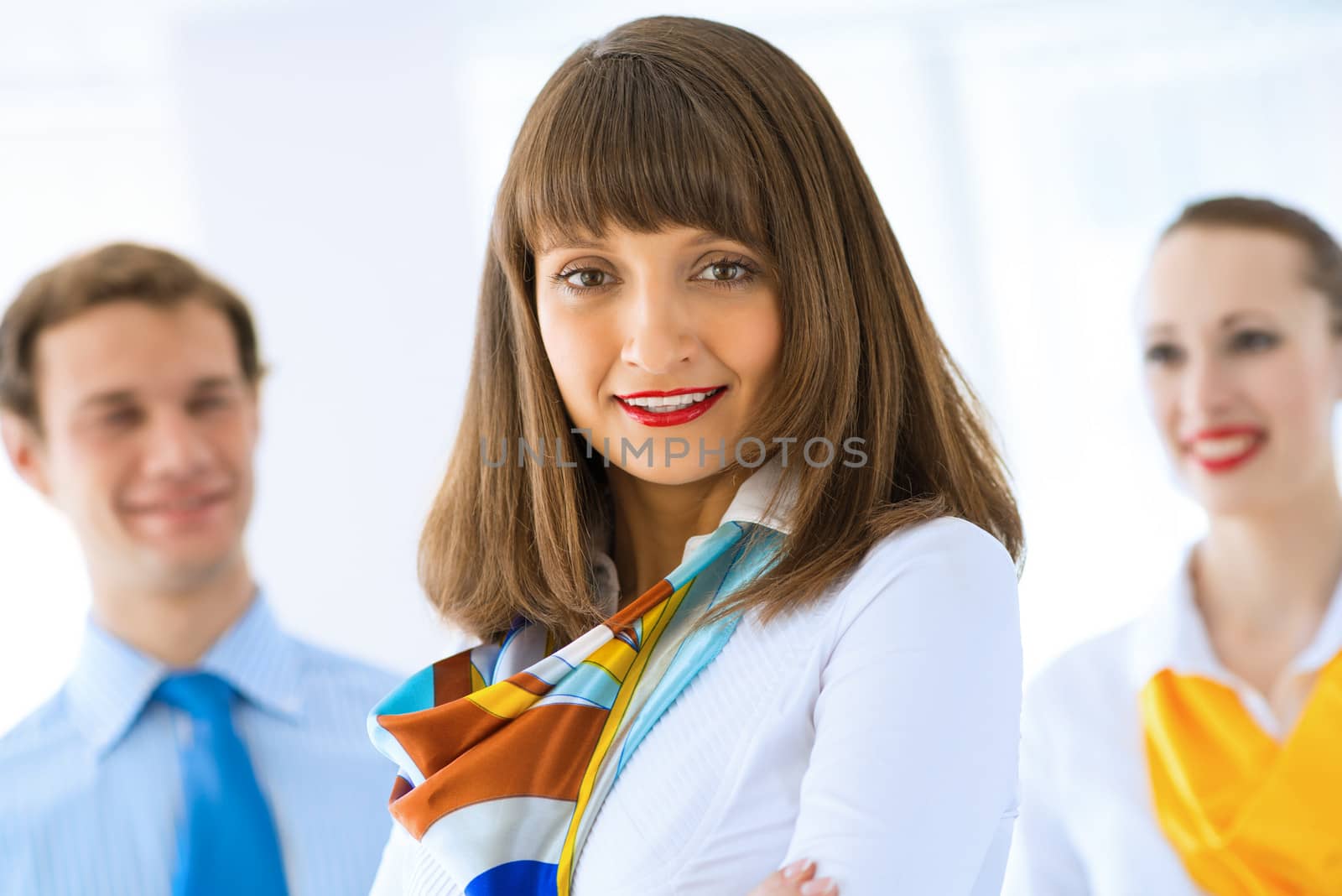 Portrait of a young successful business woman standing against colleagues