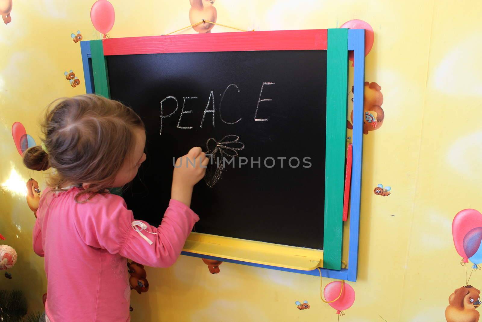 girl writes on a blackboard a word the peace by alexmak
