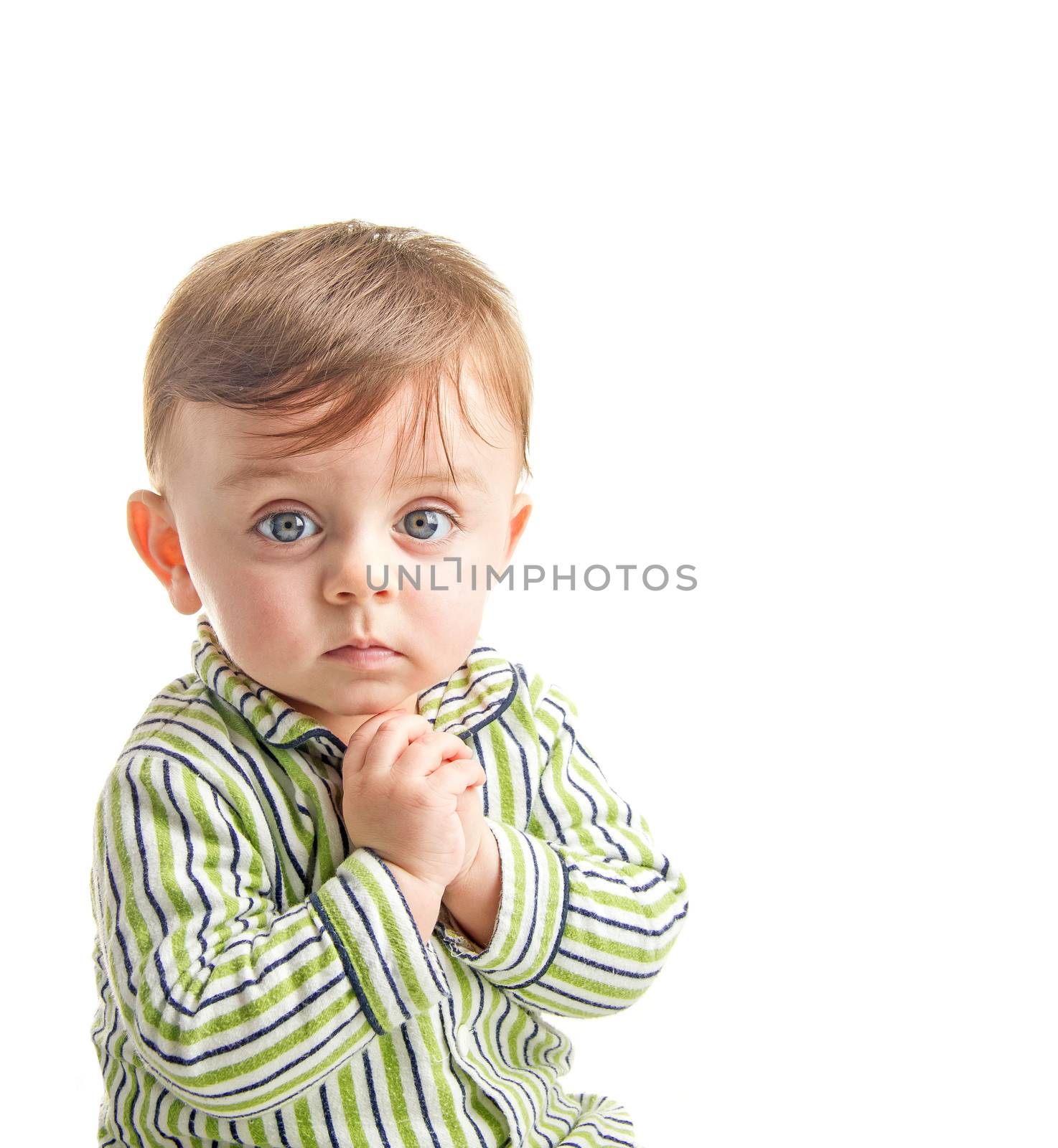 Lovely baby looking to the camera wearing his pajama holding his hands together