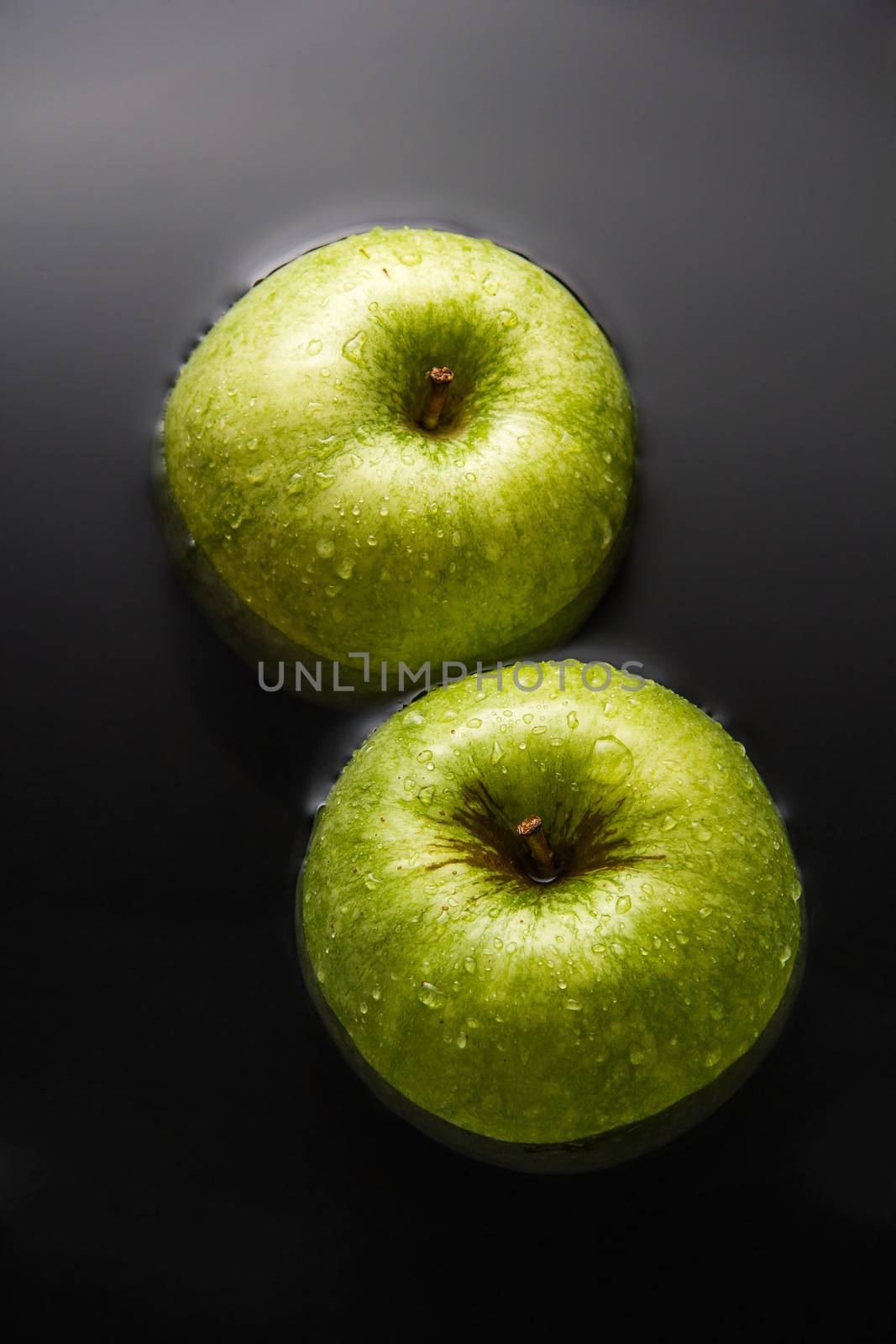 Two apples inside water with cool drops